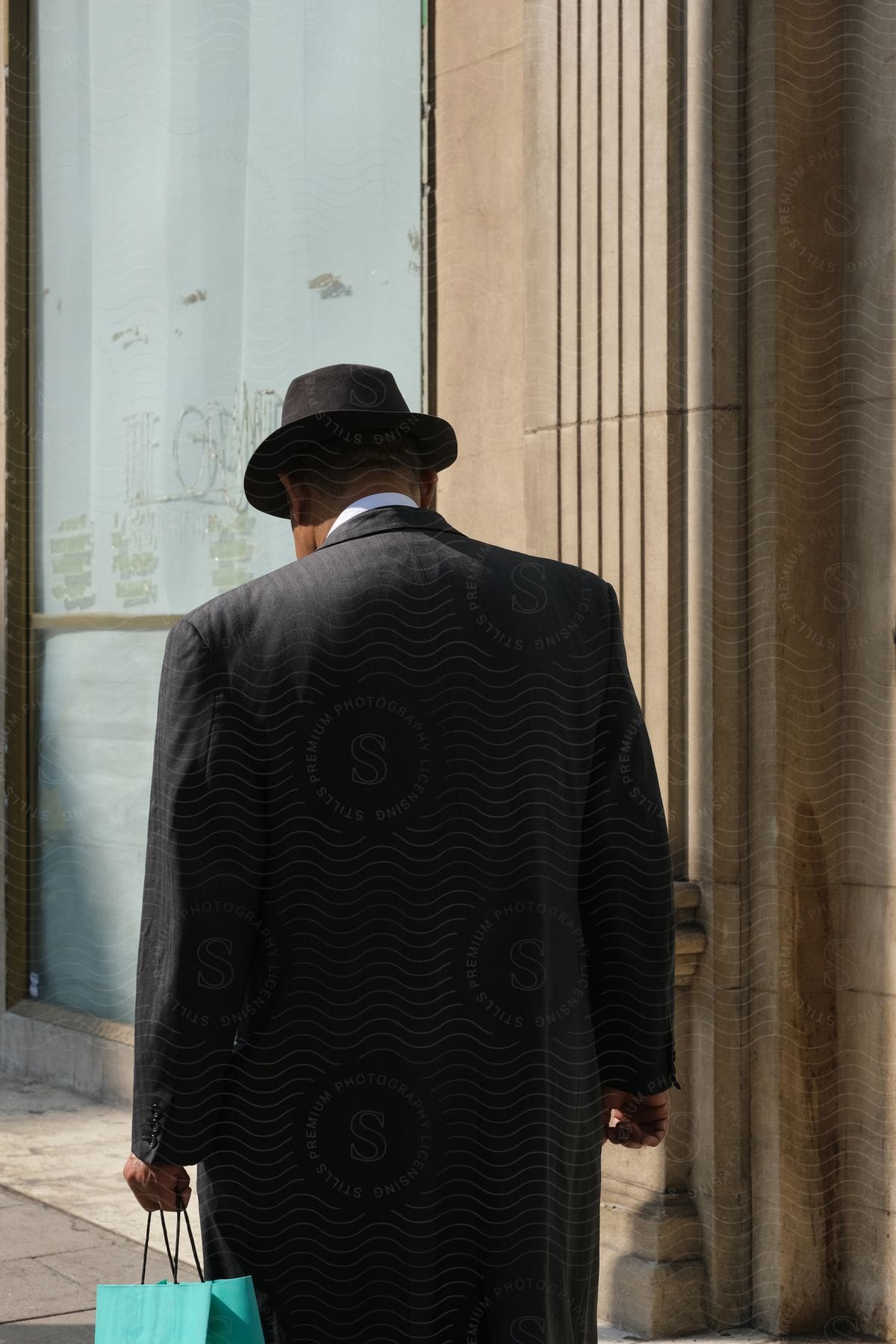 A man walking in a city while holding a bag