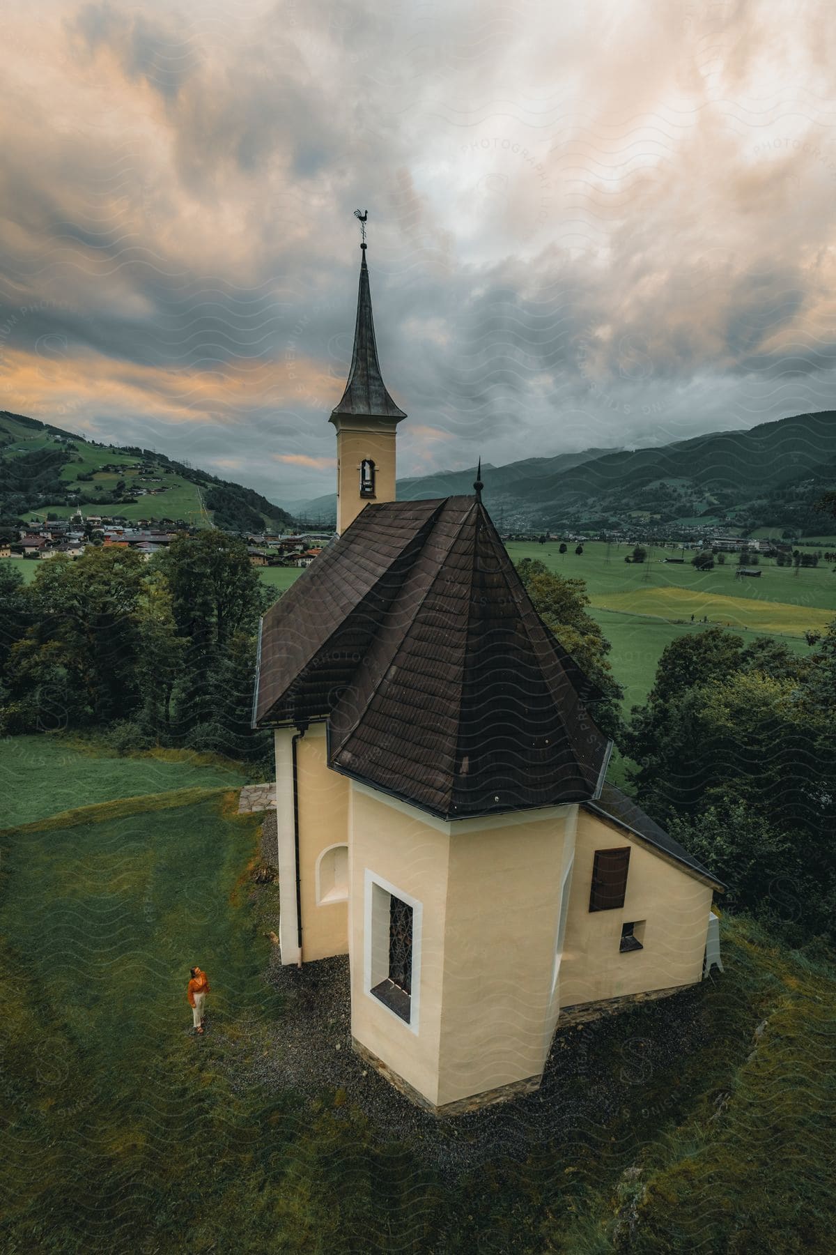 A woman admires a church in a small town from an aerial perspective