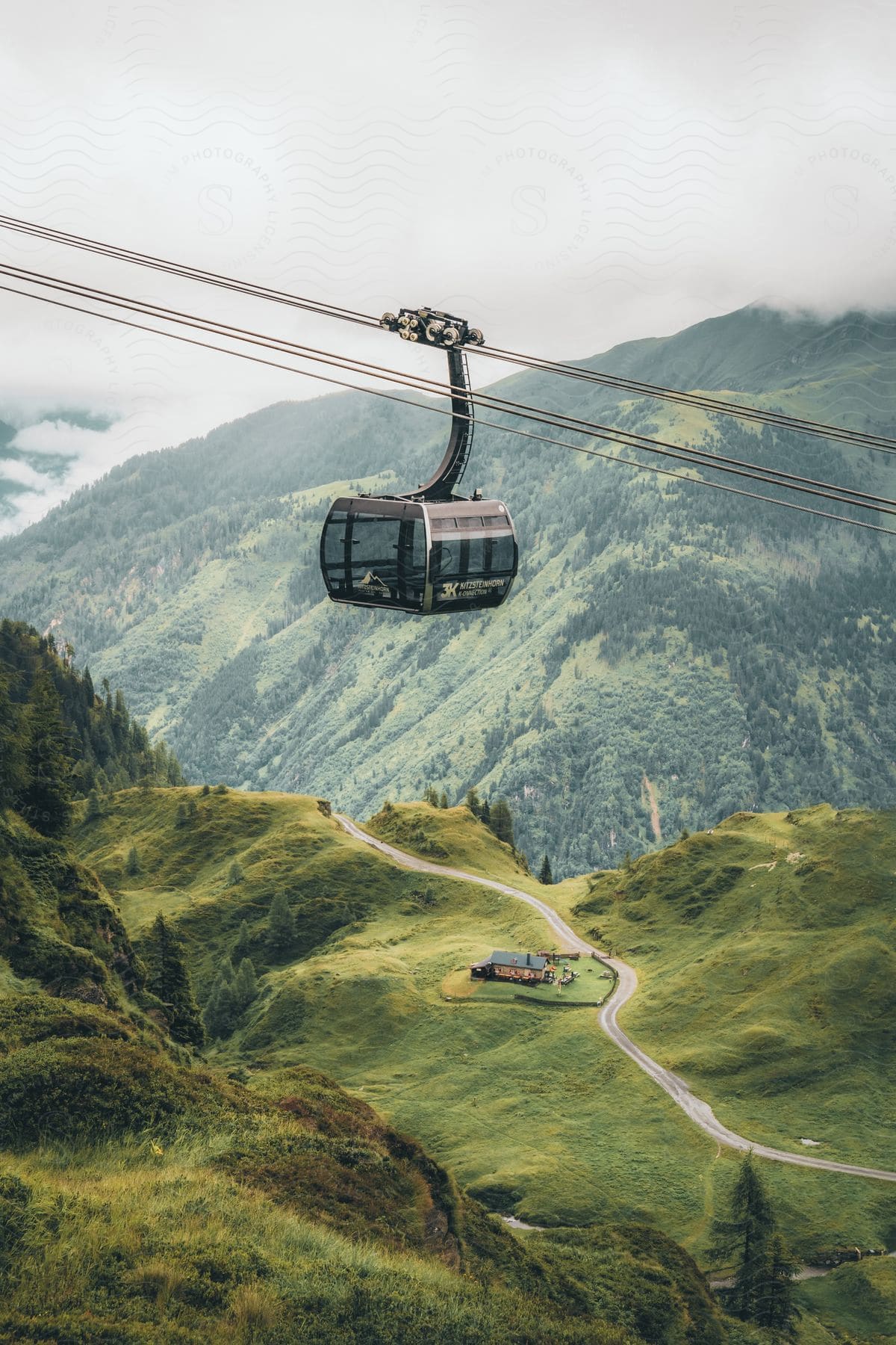 A hut on top of a mountain with a cable car in the air