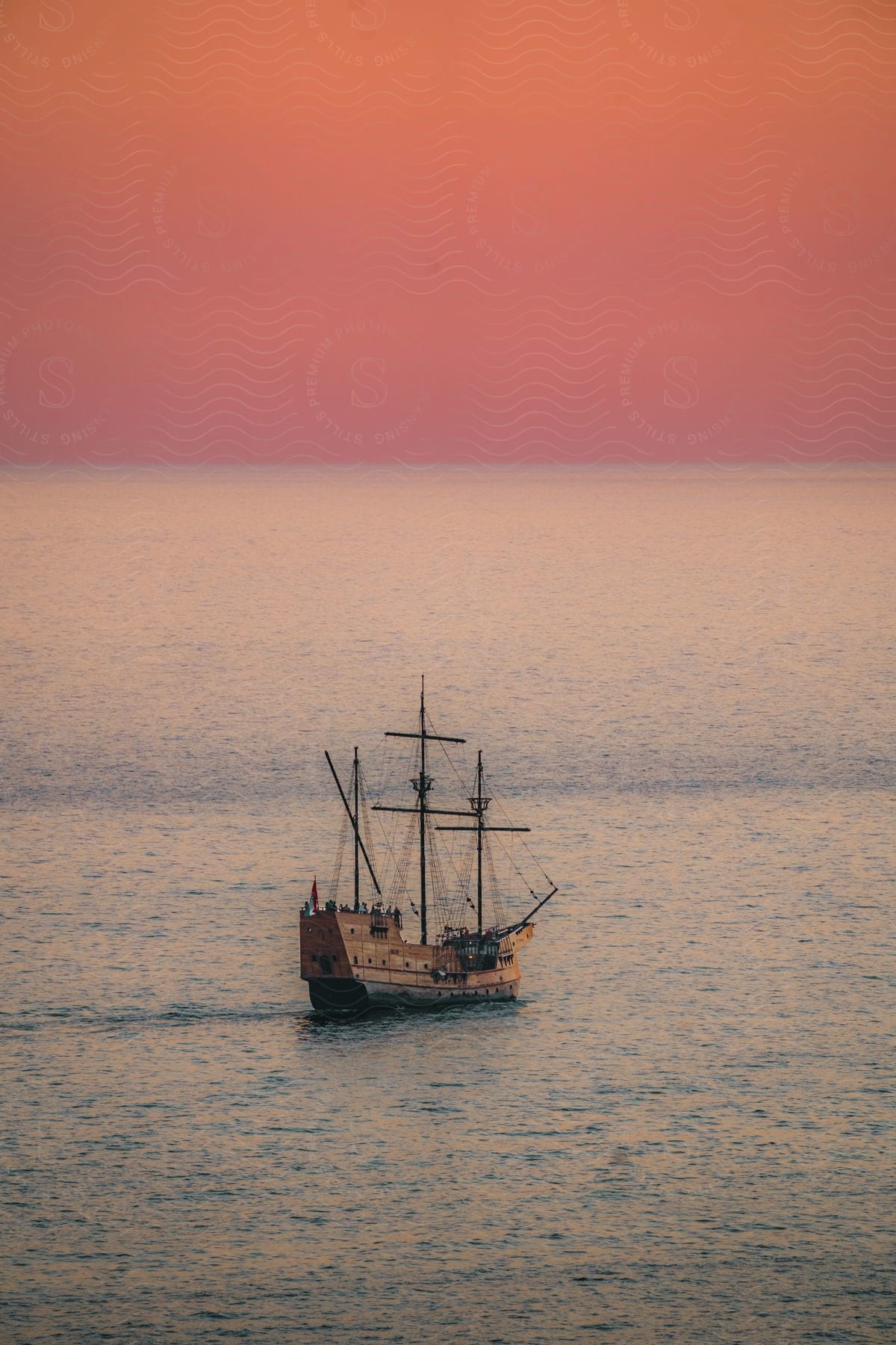 A calm sea with a canoe in it at dusk or dawn