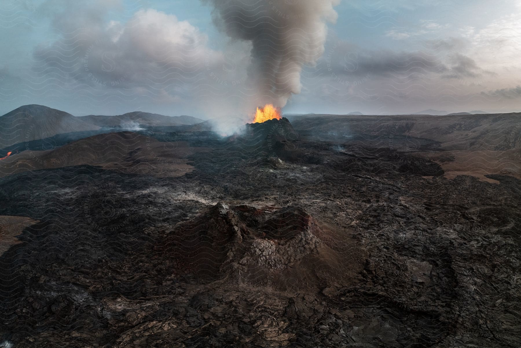 A volcano erupting in a rocky mountain plateau