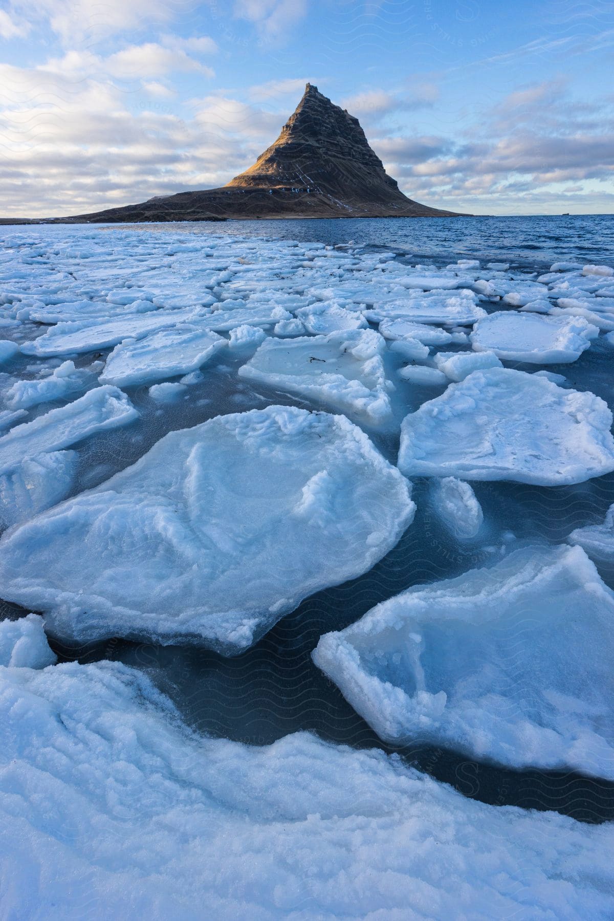 A mountain without snow or ice above a melting ice cap