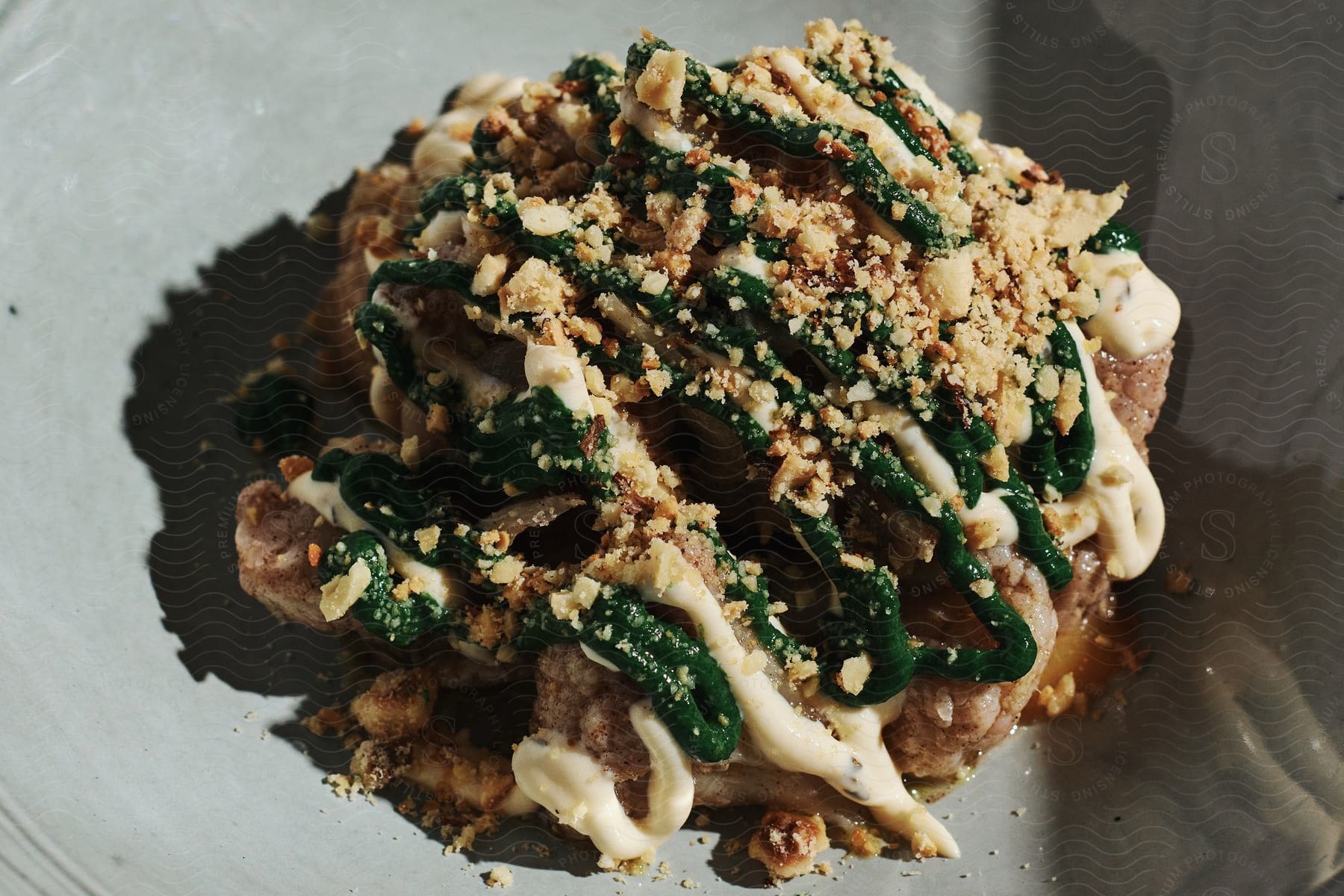 A protein cookie with white and green icing and crumb toppings