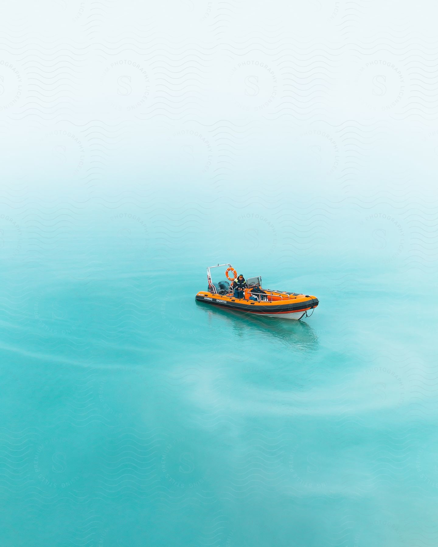 A powerboat sailing across water from an aerial perspective