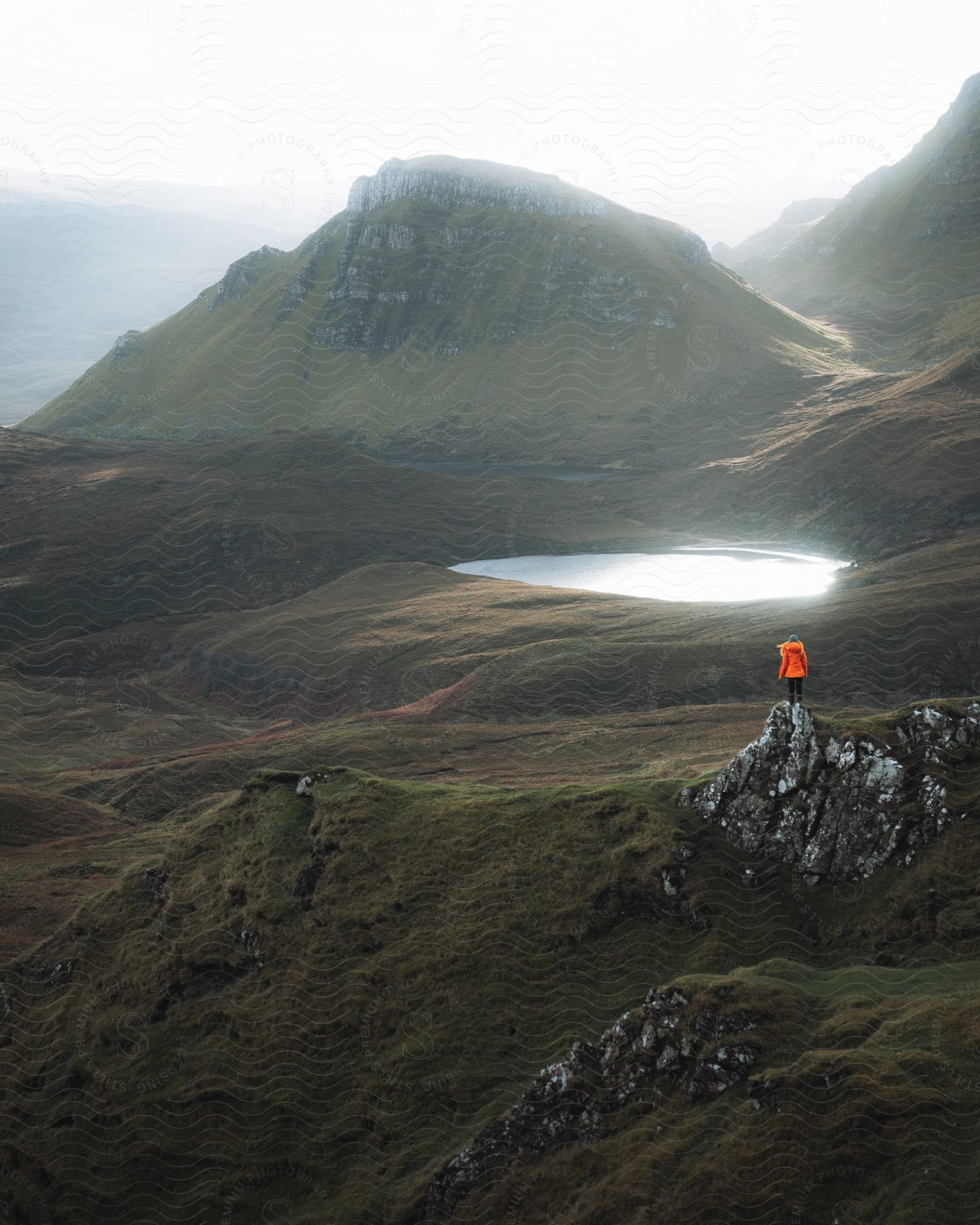 A woman standing on rocks in a mountain wilderness