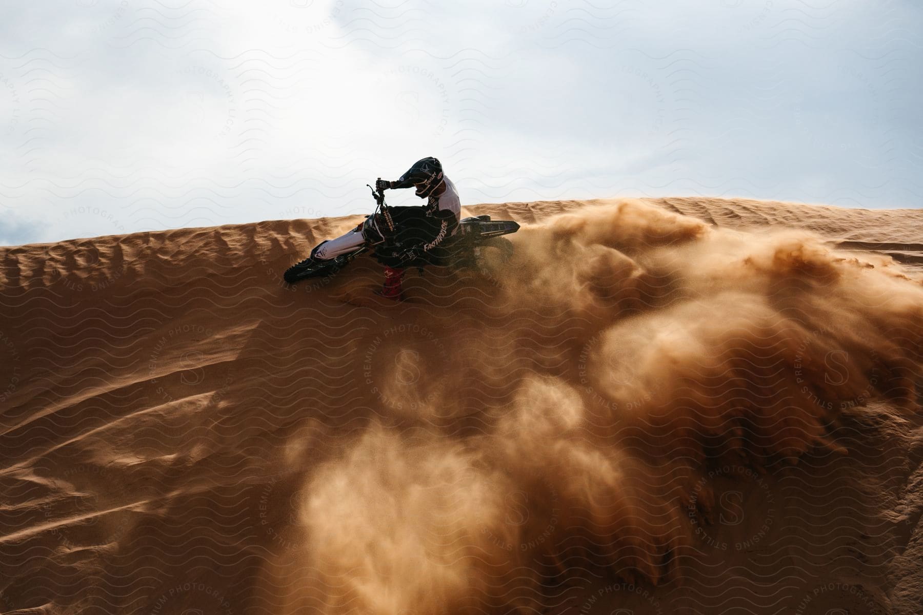 Motocross rider creating a trail of swirling dust on a course