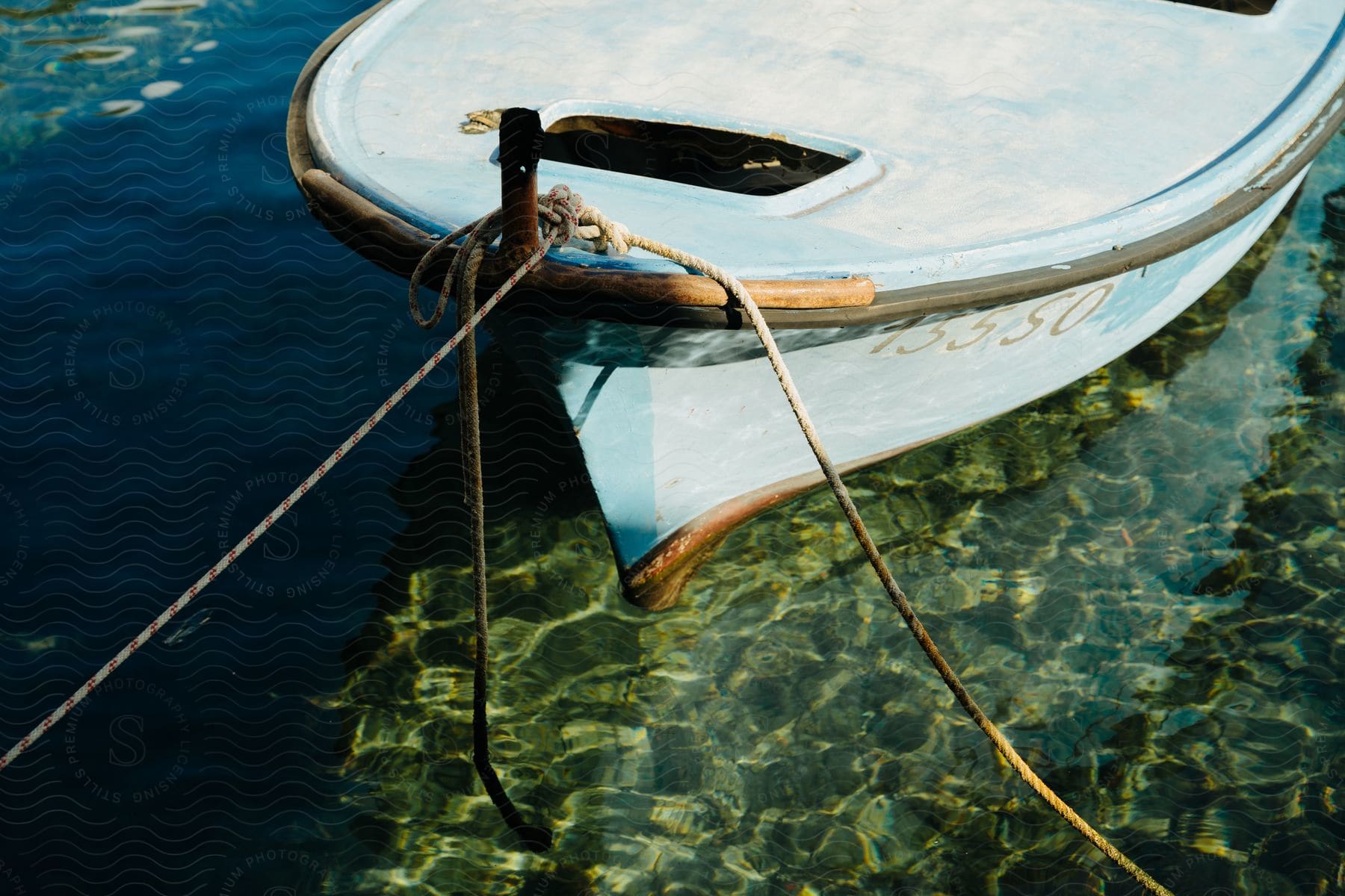 A sailboat is docked in clear water