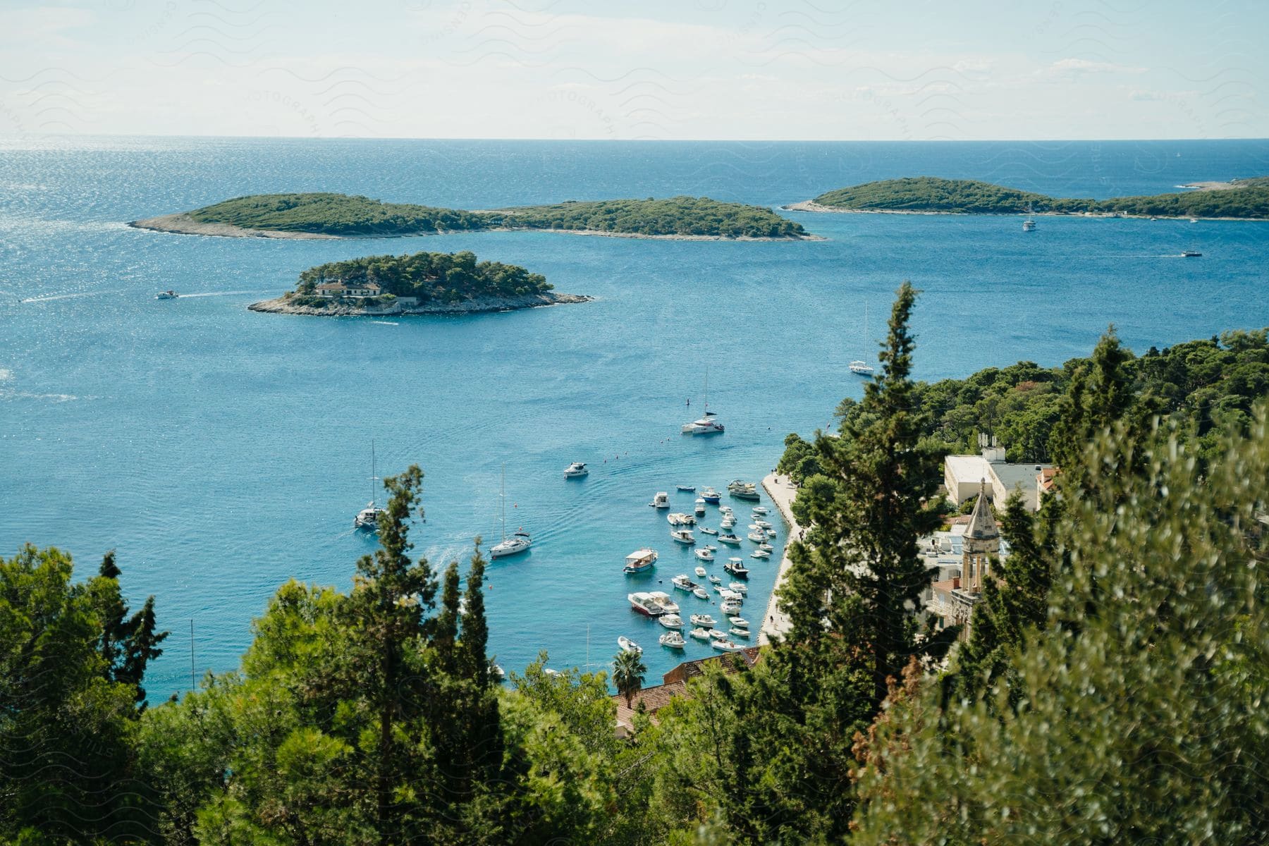 An aerial perspective of the coast and islands near an ocean port on a sunny day