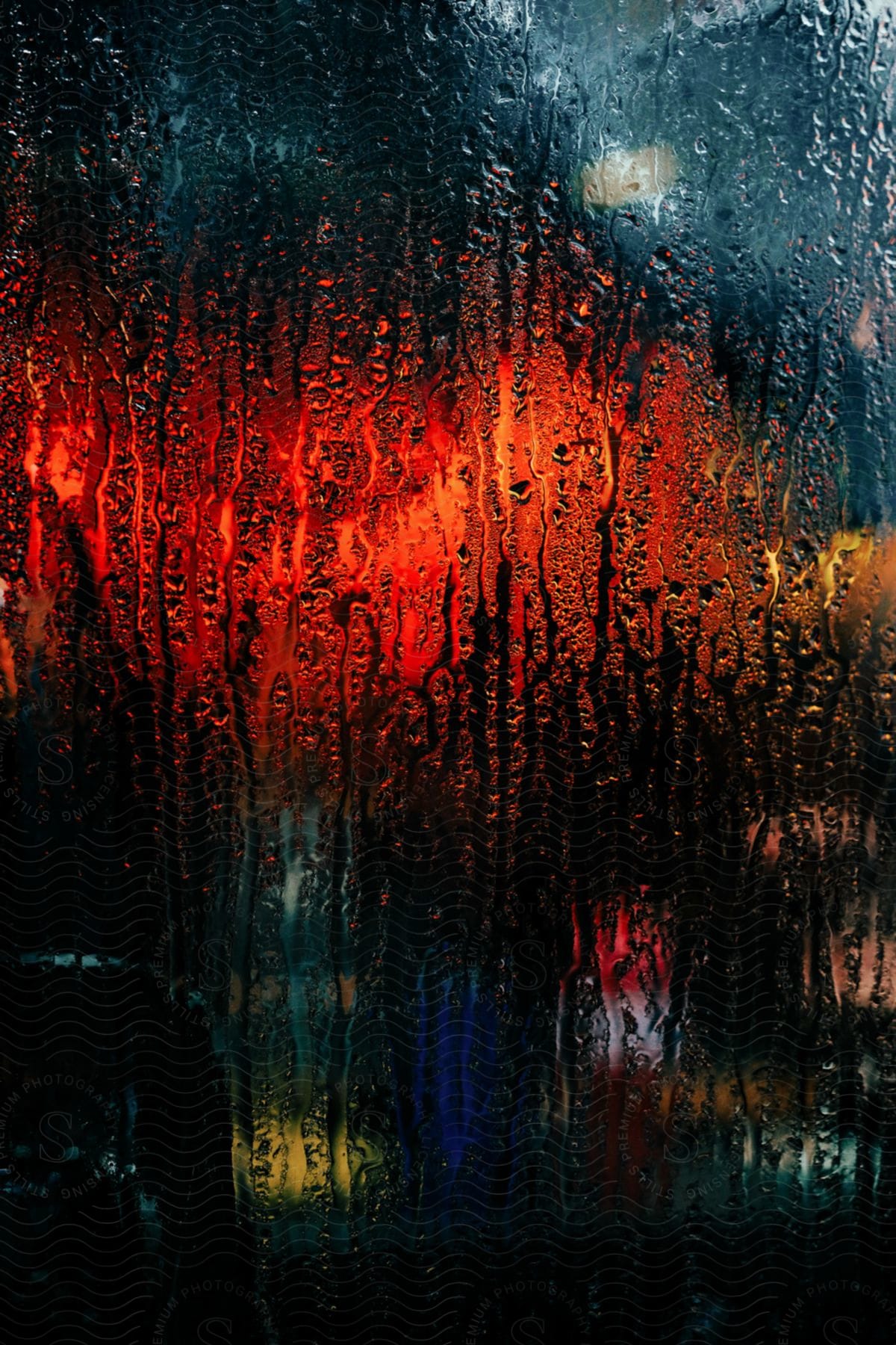 Raincovered glass reveals blurred lights