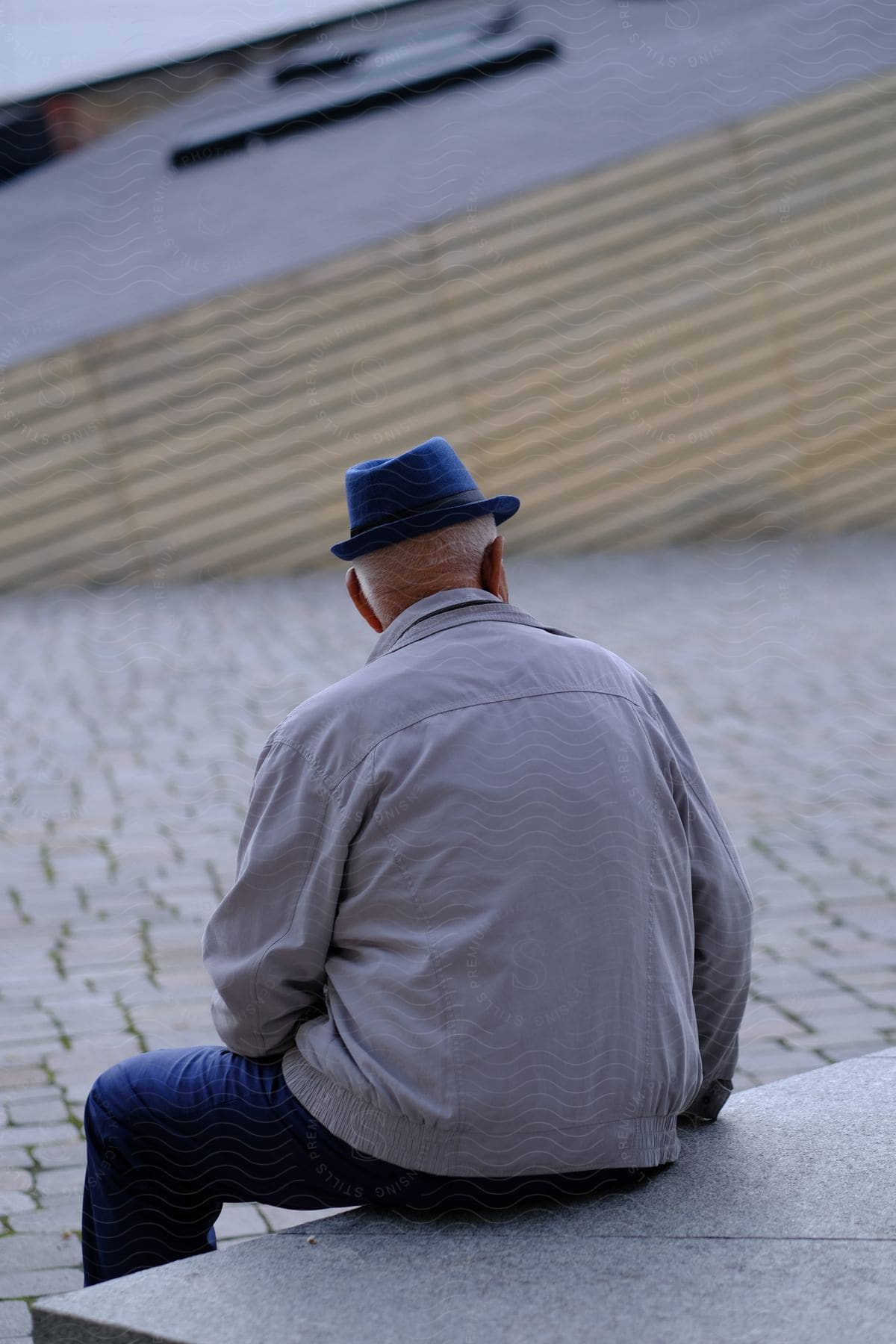 A man sitting on a stone step looking towards a building