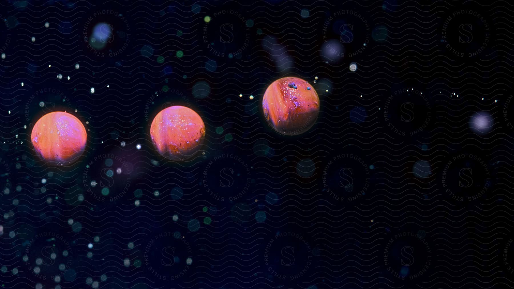 Three small pink planets in outer space