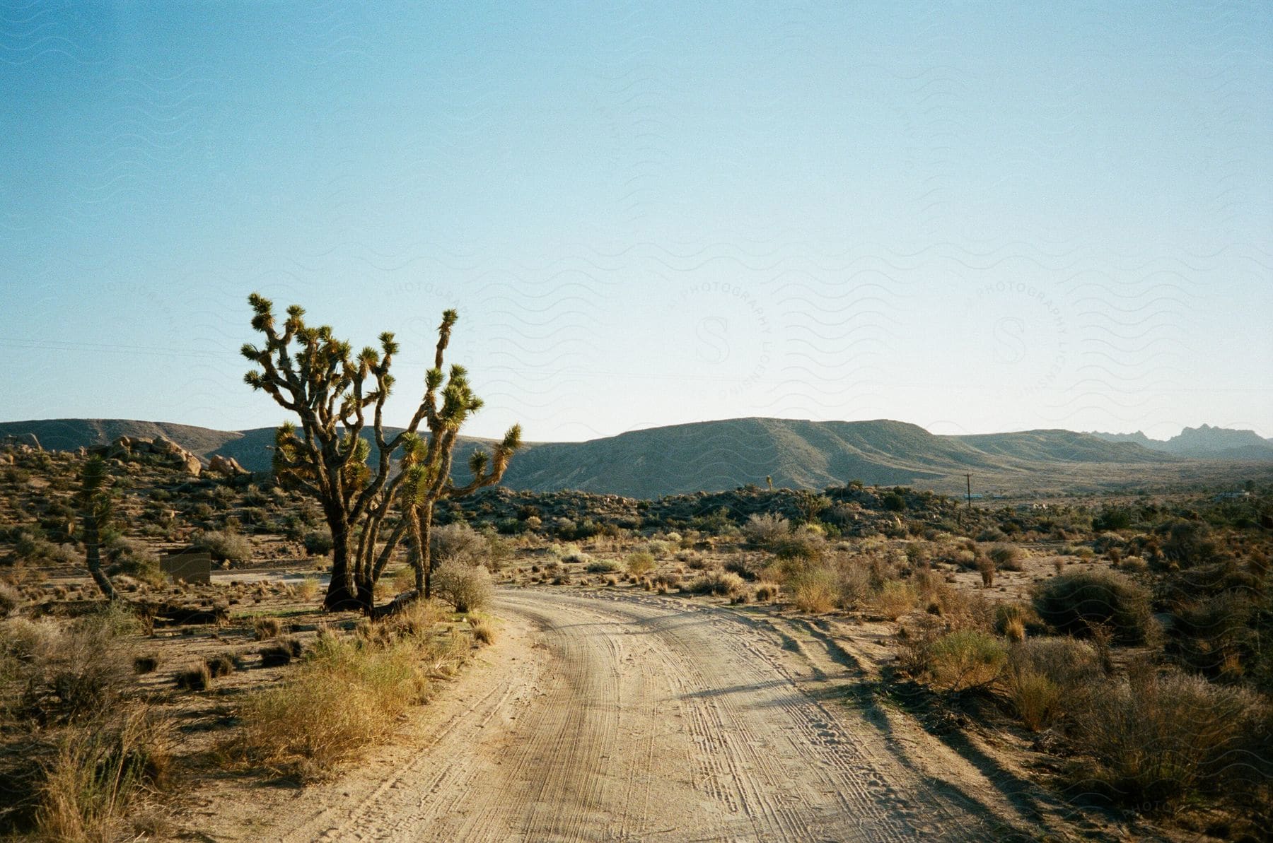 A natural landscape with mountains clouds and a road