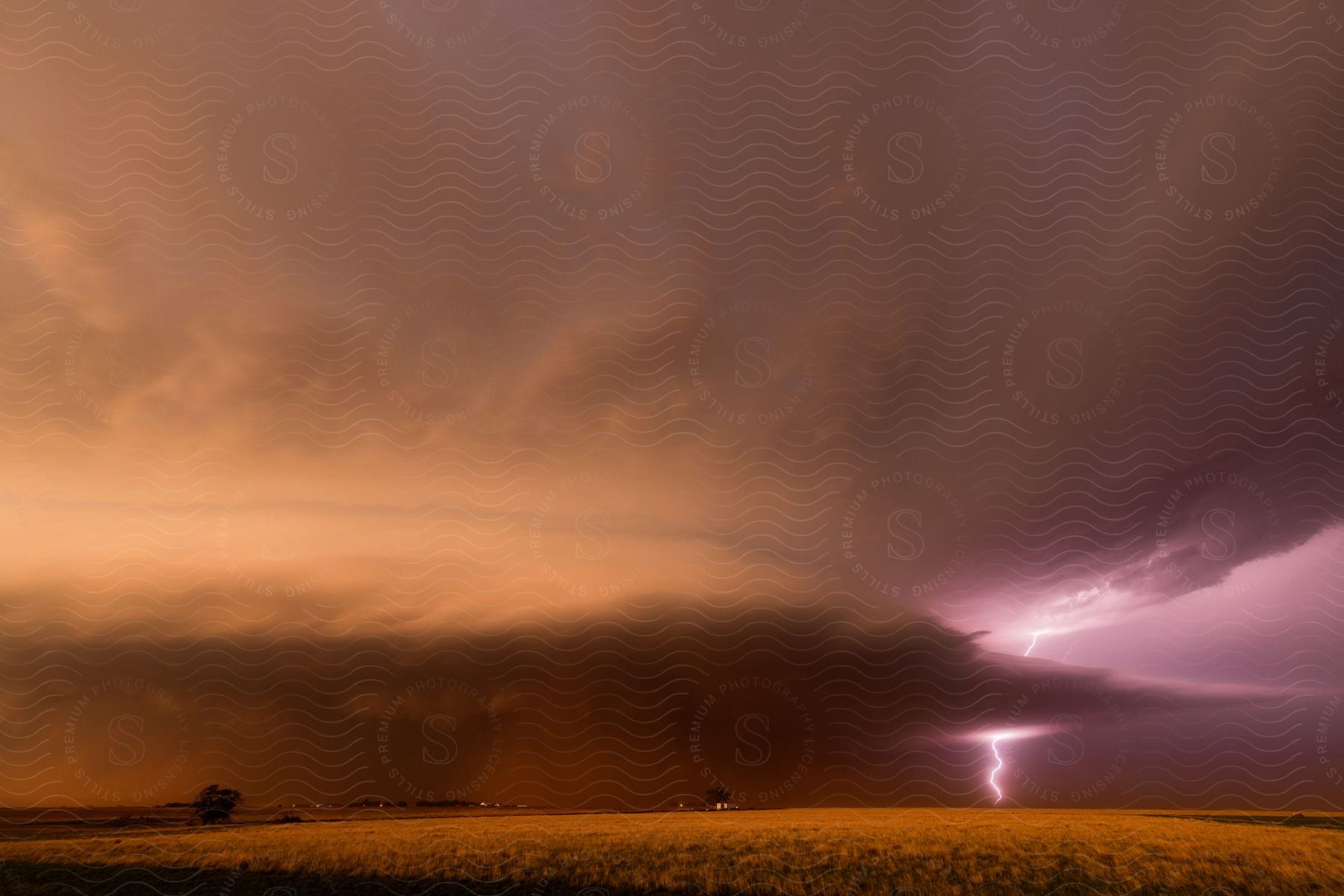 Lightning Strikes The Ground Under Storm Clouds Near A Rural Town In The Countryside At Dusk