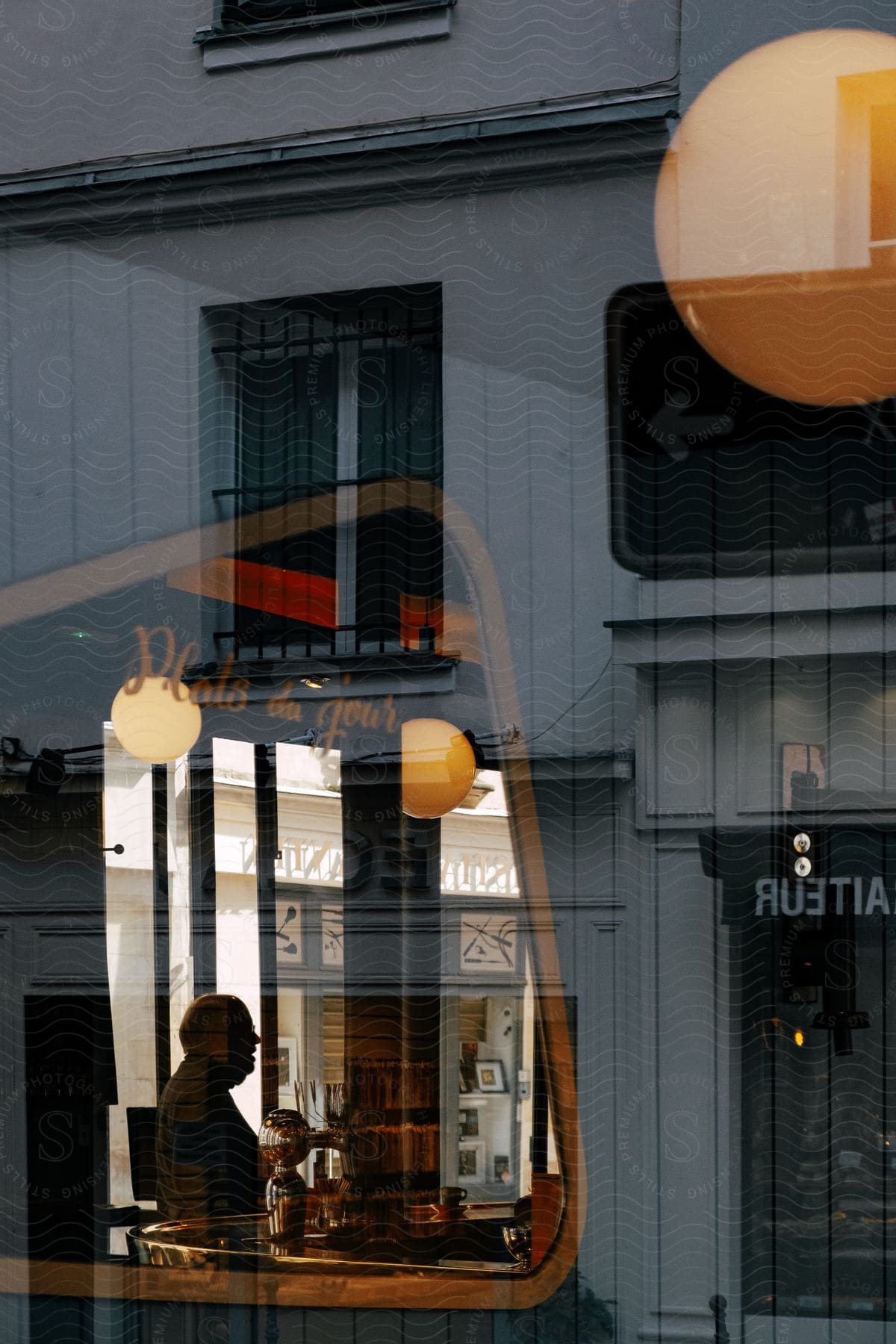 A man stands inside the window of a restaurant