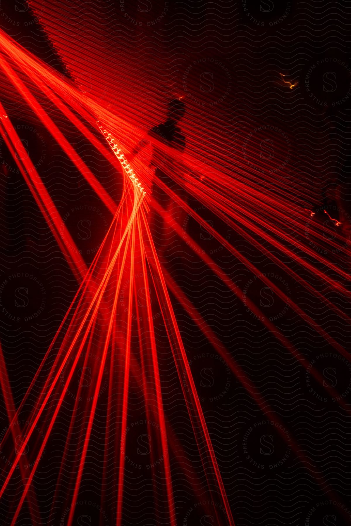 A room with red rays of light and a person standing in the middle