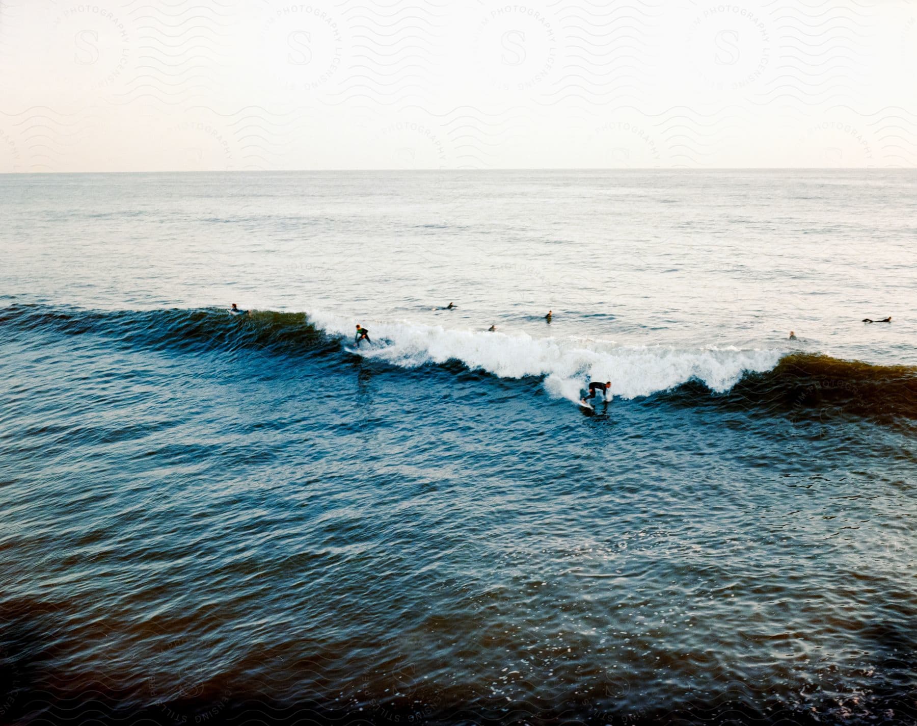 People swimming and surfing in the water on a summer day