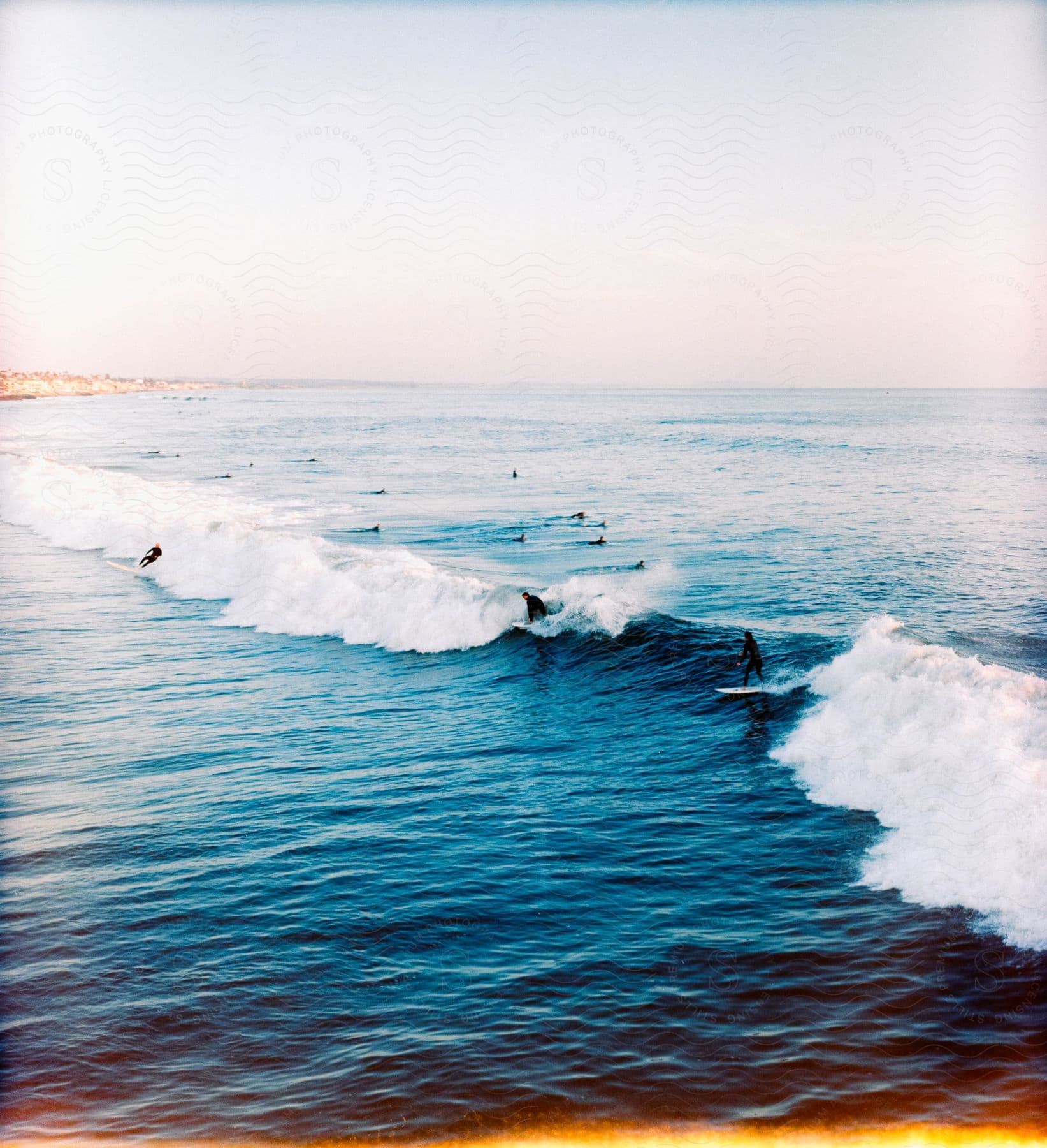 People swimming and surfing in the water on a summer day