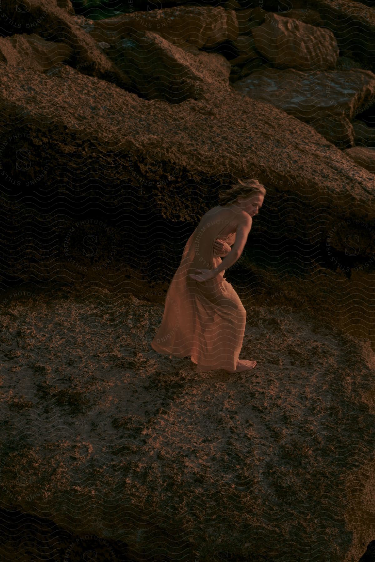 A lady exercises around the rocks barefoot.