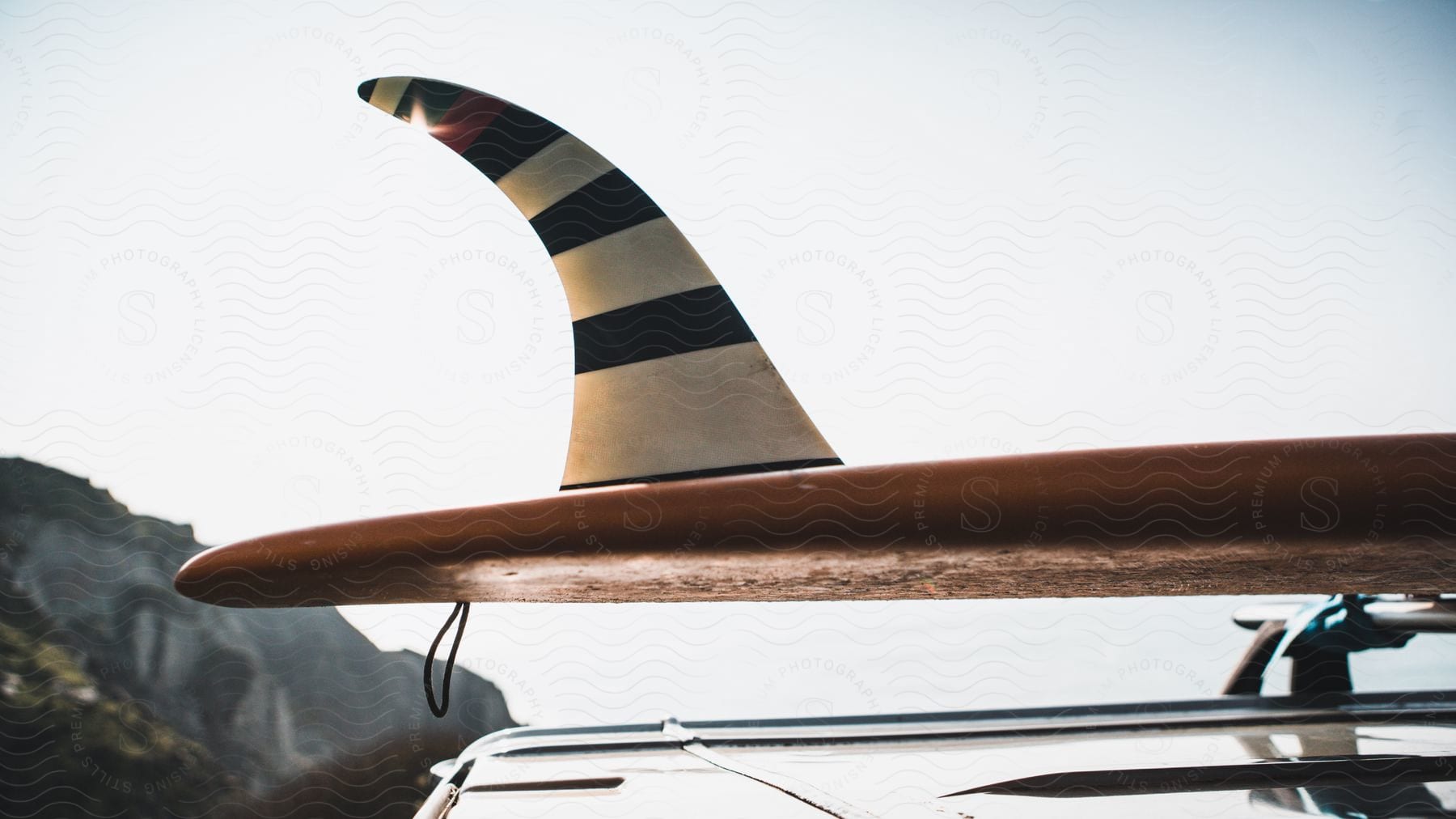 A surfboard is strapped to the roof of a car