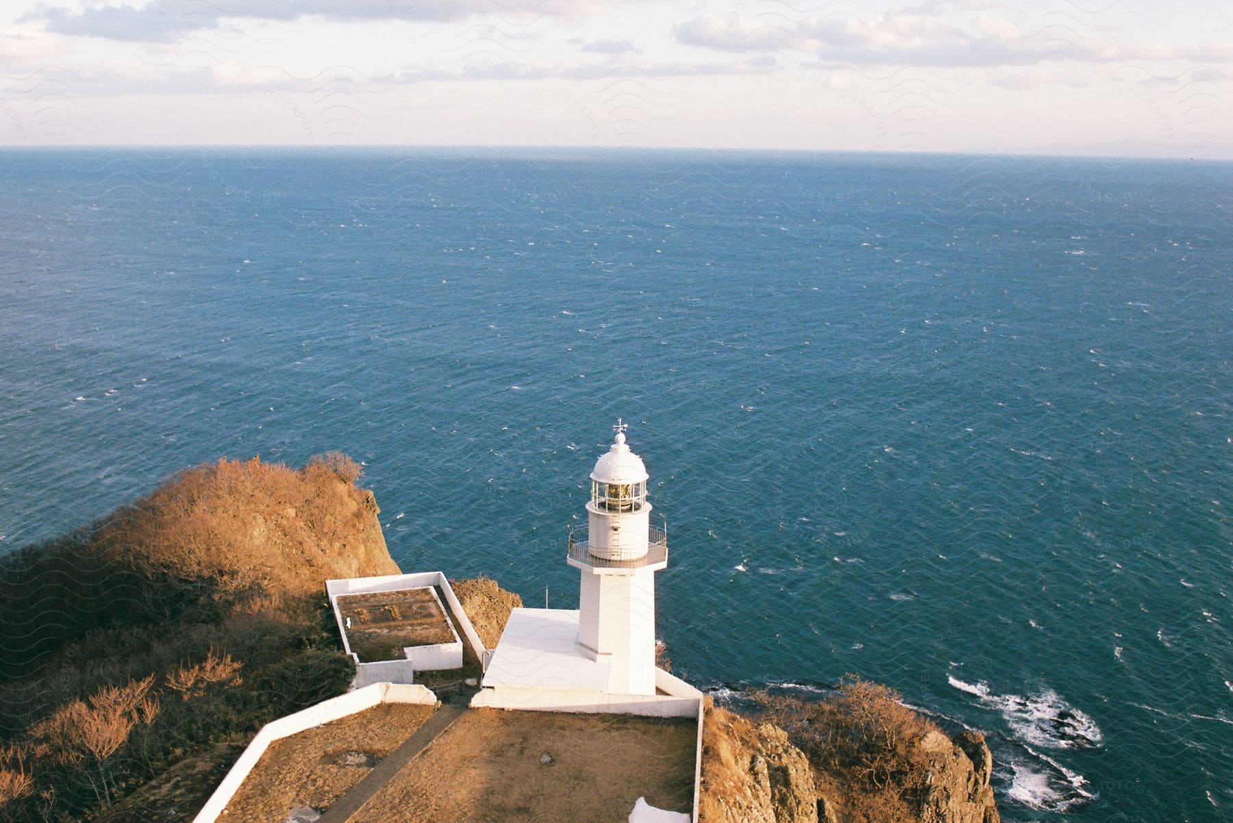 A large lighthouse stands along the coast