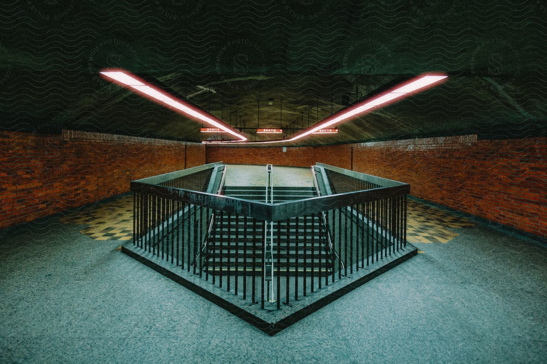 A tunnel railing leading to stairs in a subway station