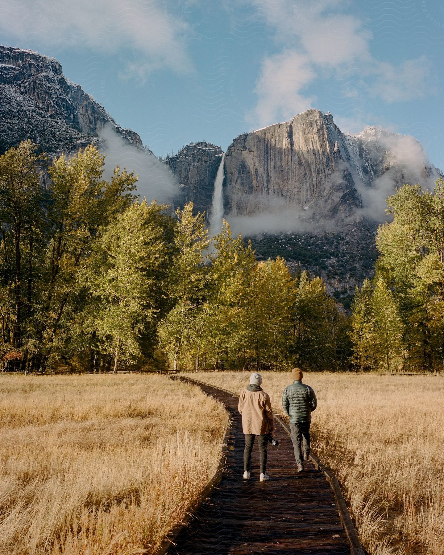 Couple exploring yosemite park with waterfall in the background