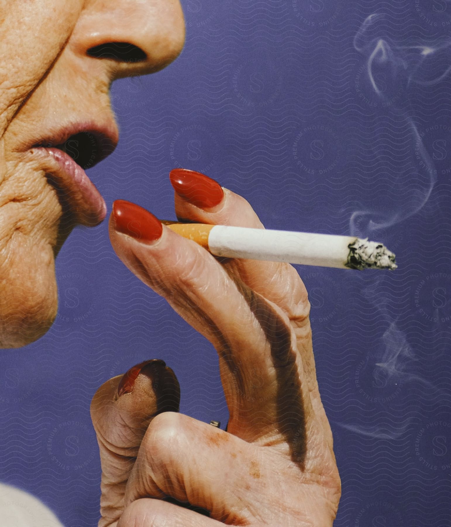 Close up of an elderly womans fingers holding a cigarette