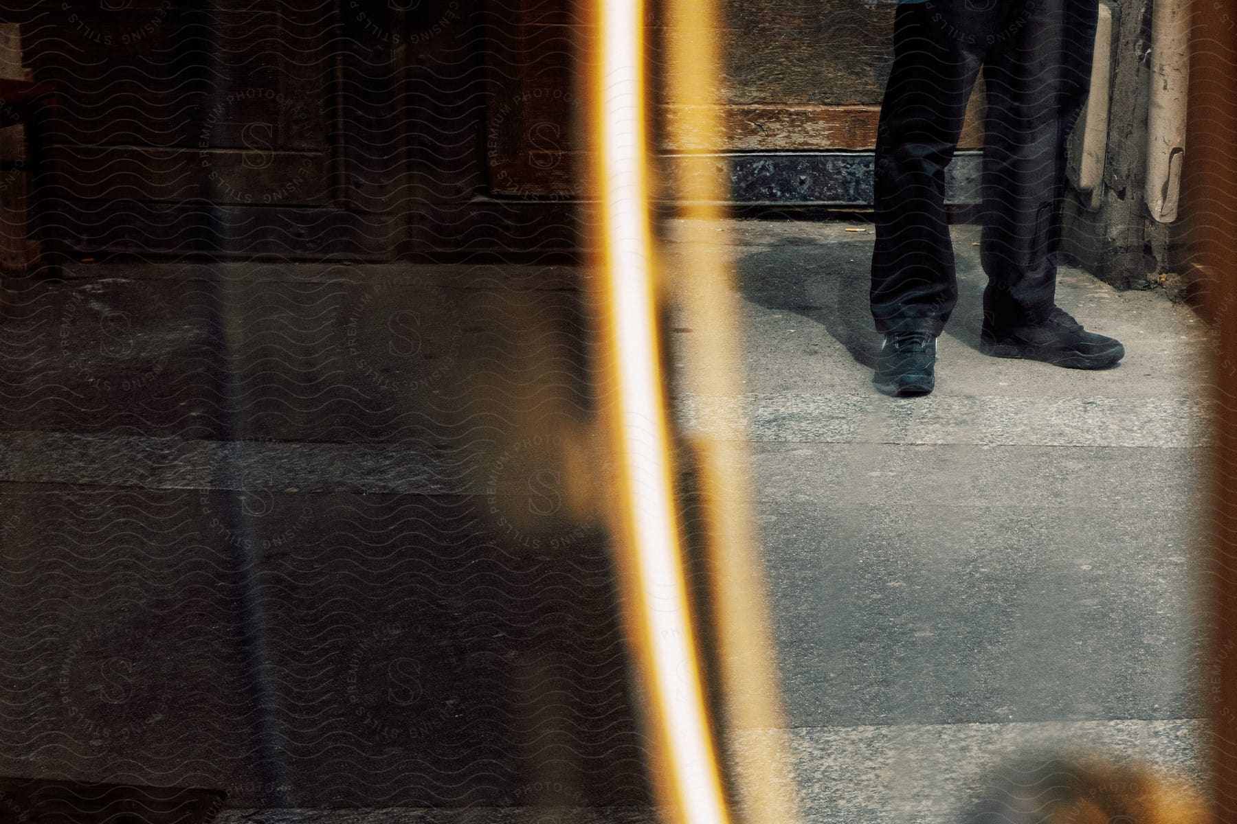 A man wearing jeans and shoes standing on a wooden floor