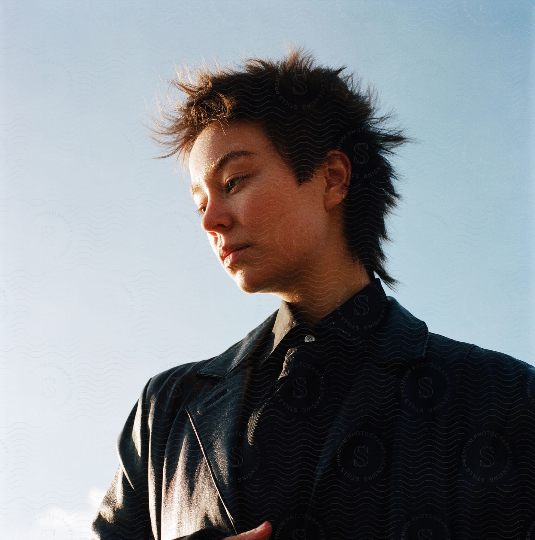 An asian woman with short hair modeling in a black suit and tie