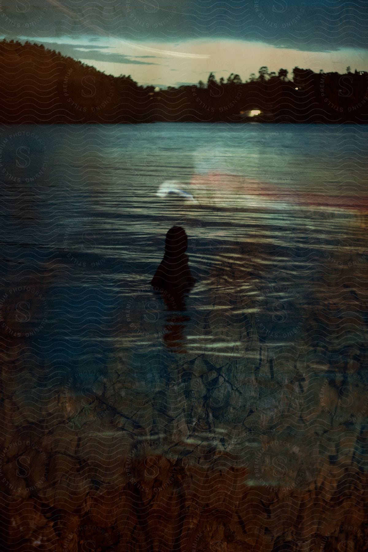 A woman sitting in a lake during dusk