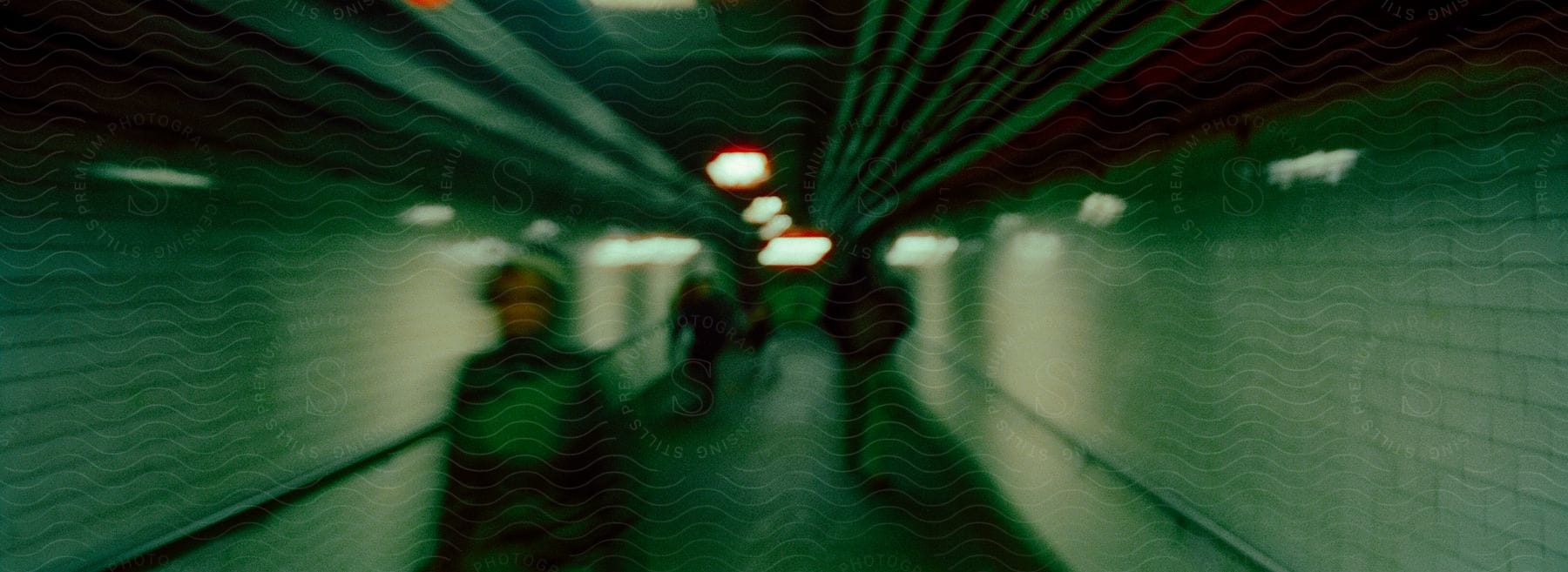 A small group of people walking through a tunnel with a blurry effect