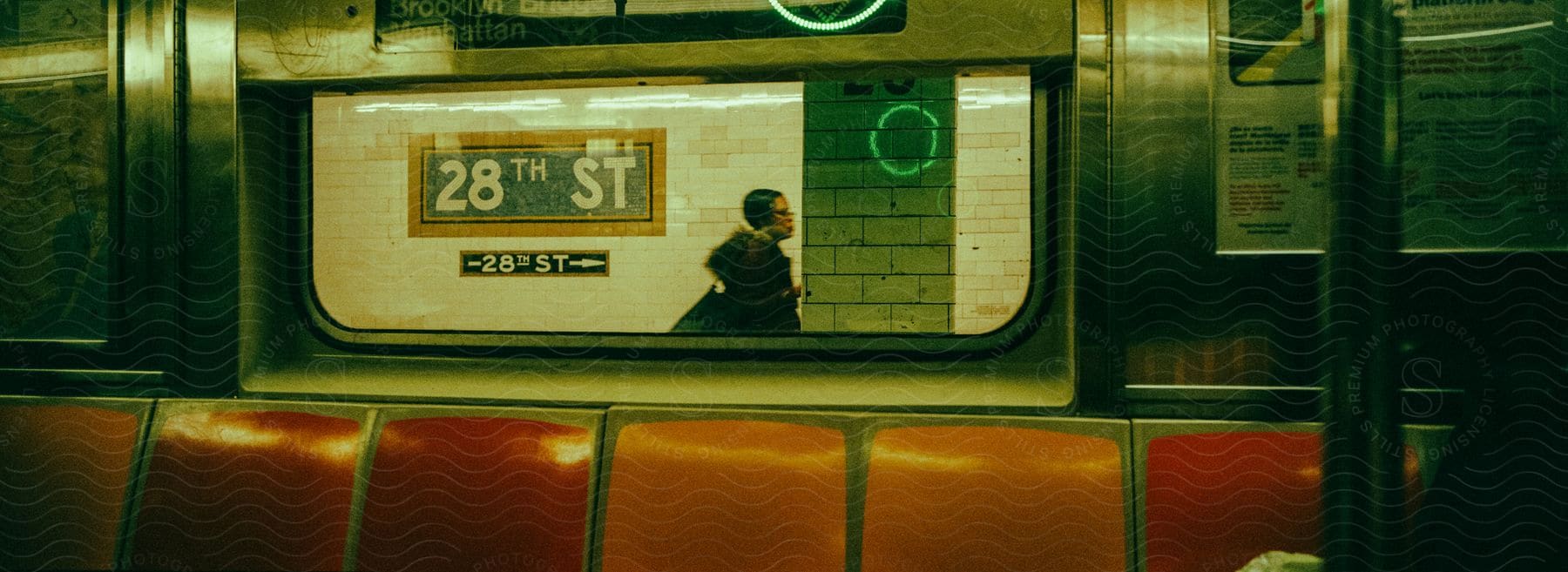 A person walking outside of a passenger train at a station