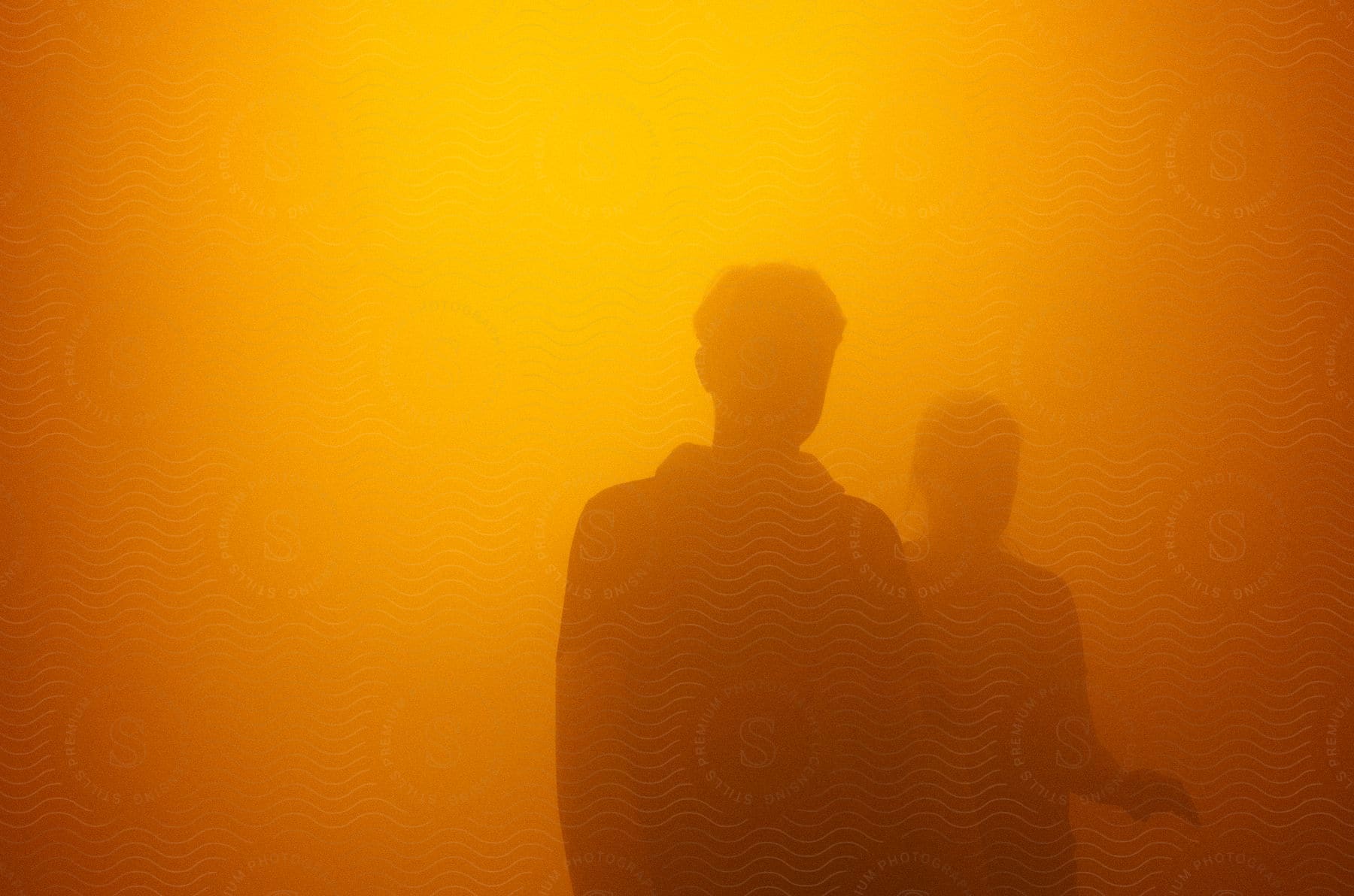 A man and woman walk through a dust cloud bathed in golden light