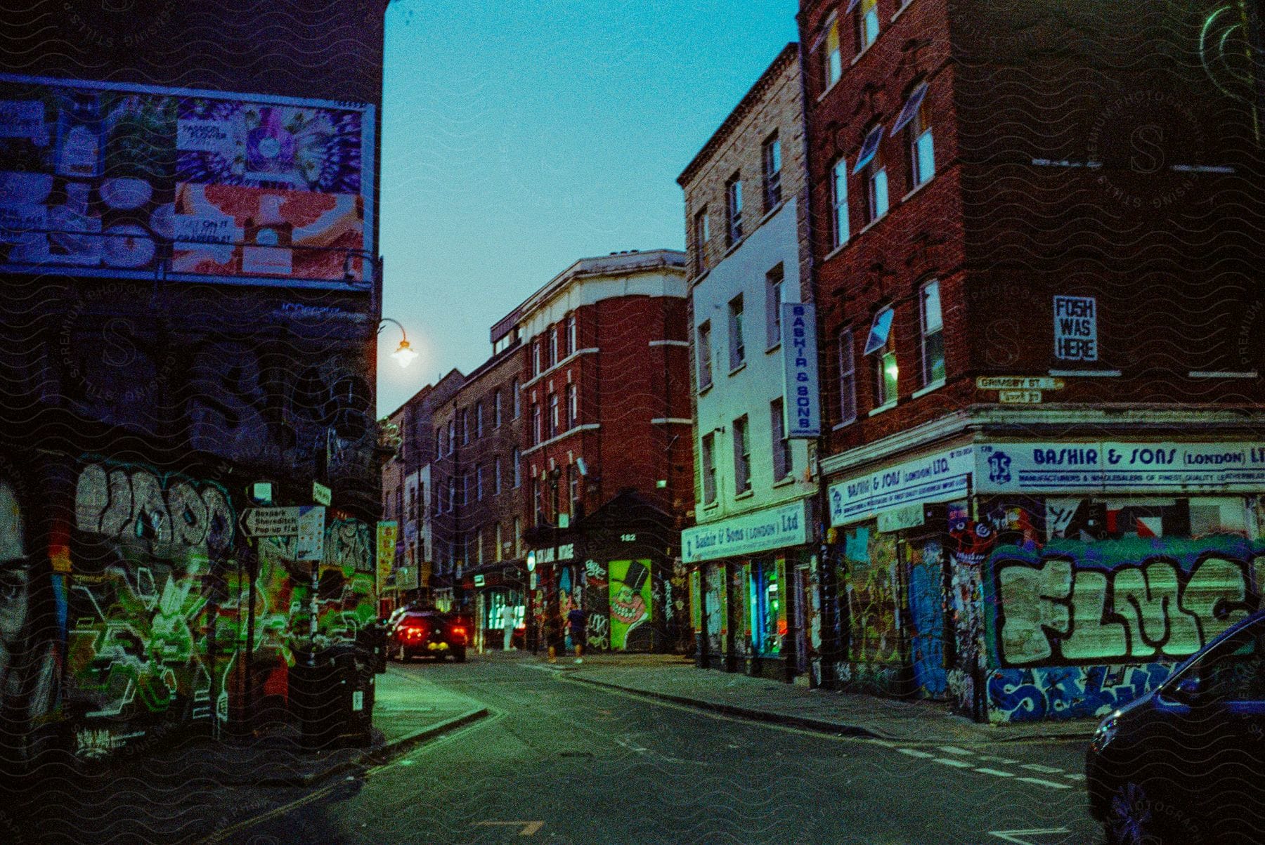 A busy city street with graffiticovered buildings cars people and advertisements