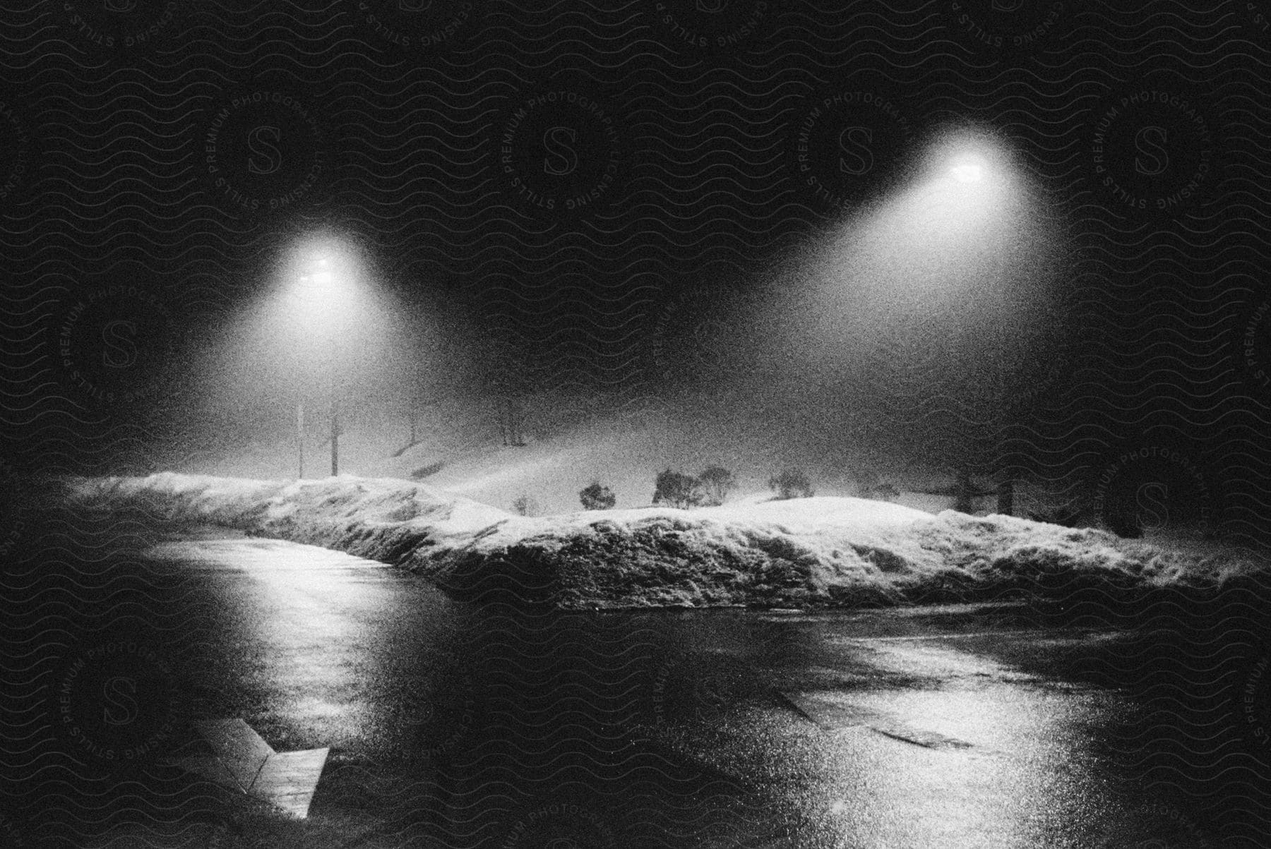 Street lights illuminate falling snow mist snow banks and slick streets on a snowy night