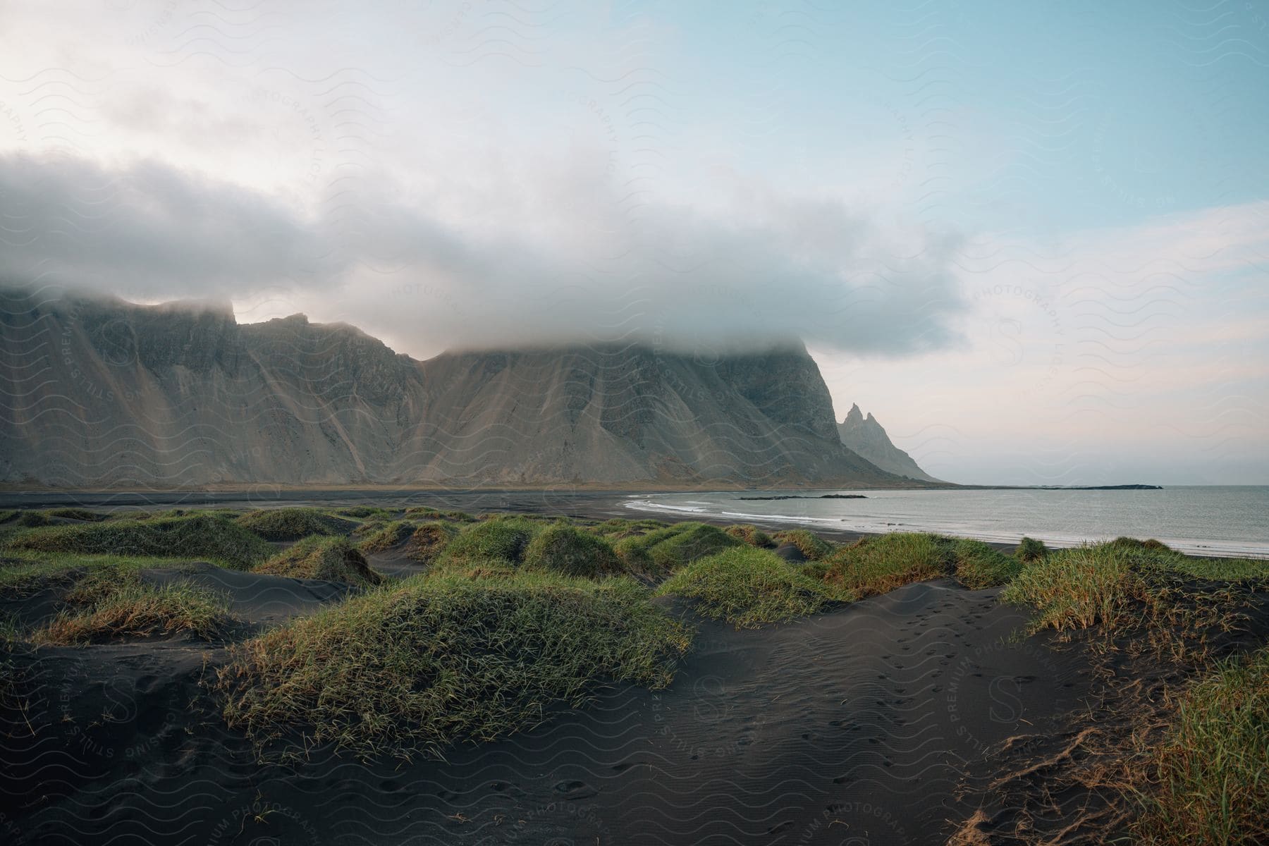 Cloudcovered mountain peaks at the ocean beach