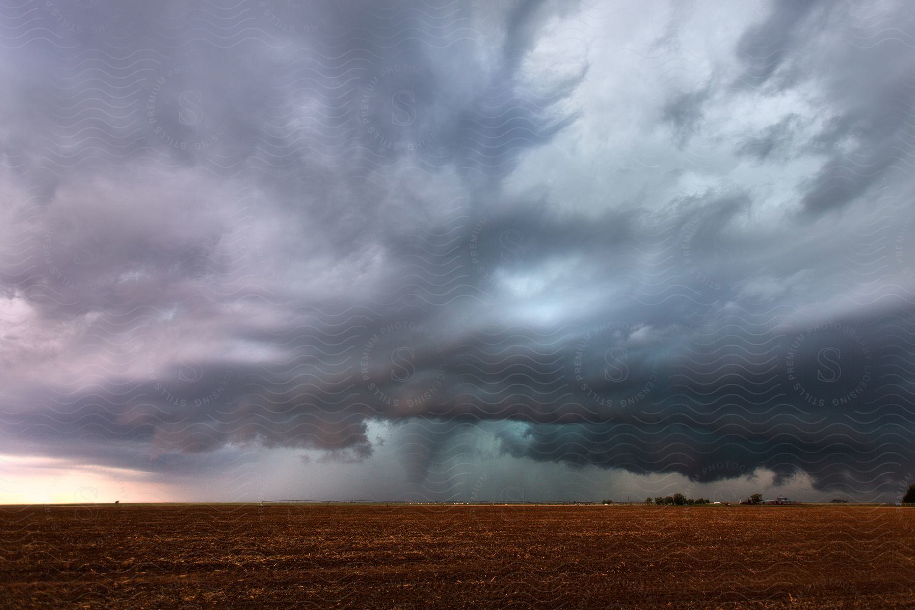 Rain and clouds during a thunderstorm over farmland in the plains