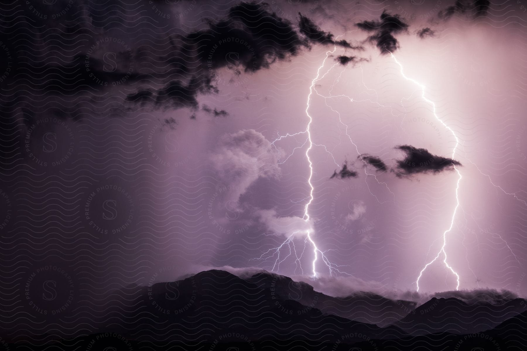 Rain and lightning fall on a mountain range