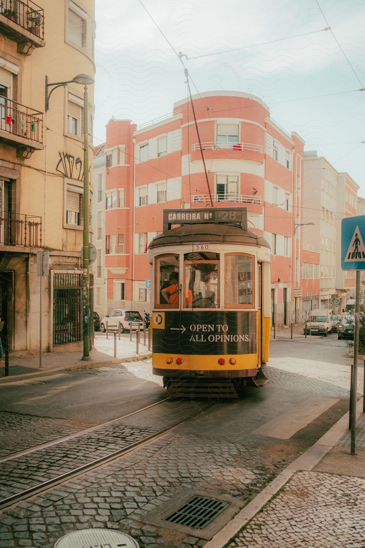 Two people walking on a city street with buildings and transportation in the background