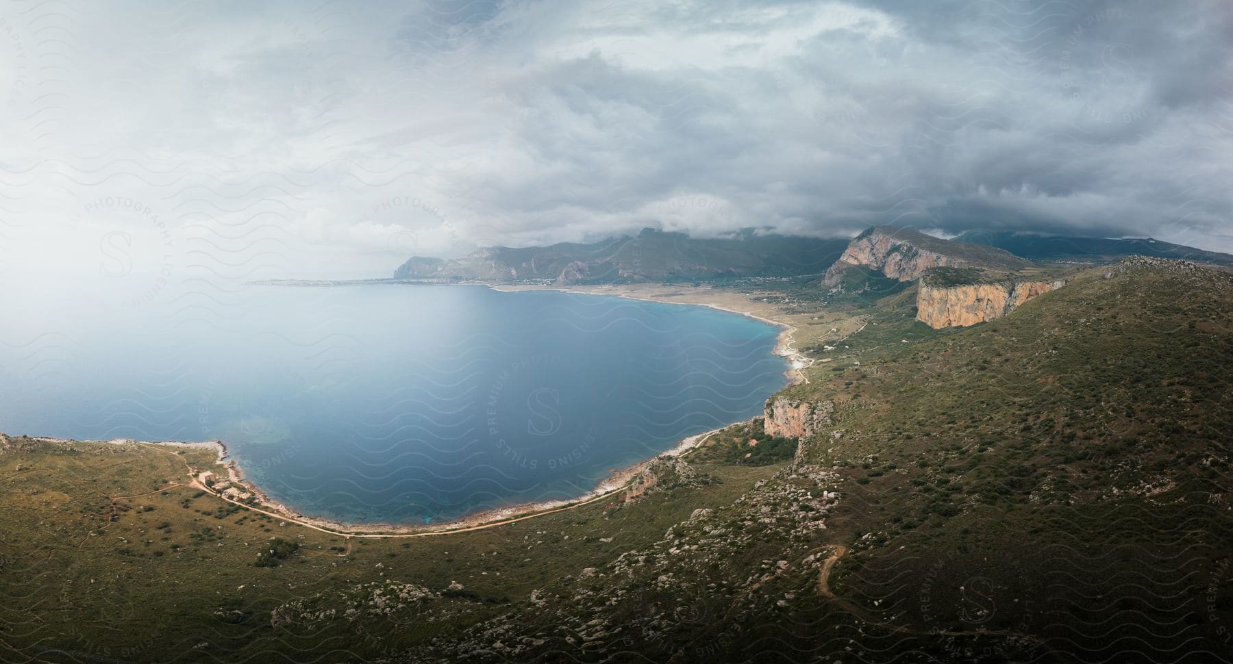 Aerial view of a mountainous shoreline with a lake and beach