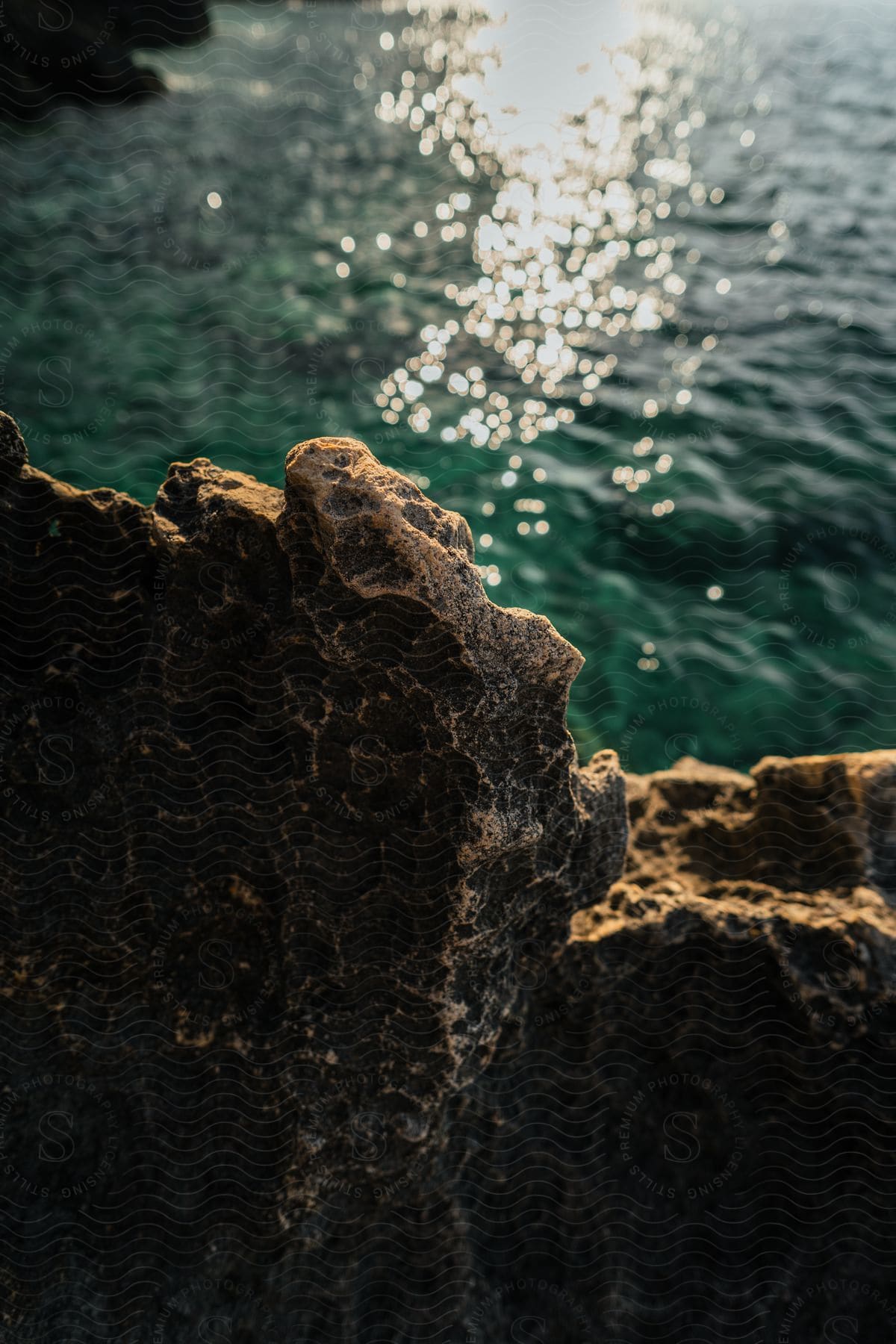 A rocky cliff overlooks clear blue water