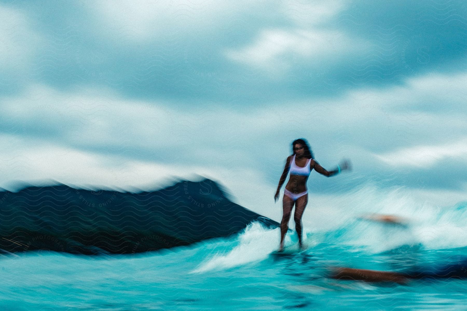 A woman surfing in ocean water during midday