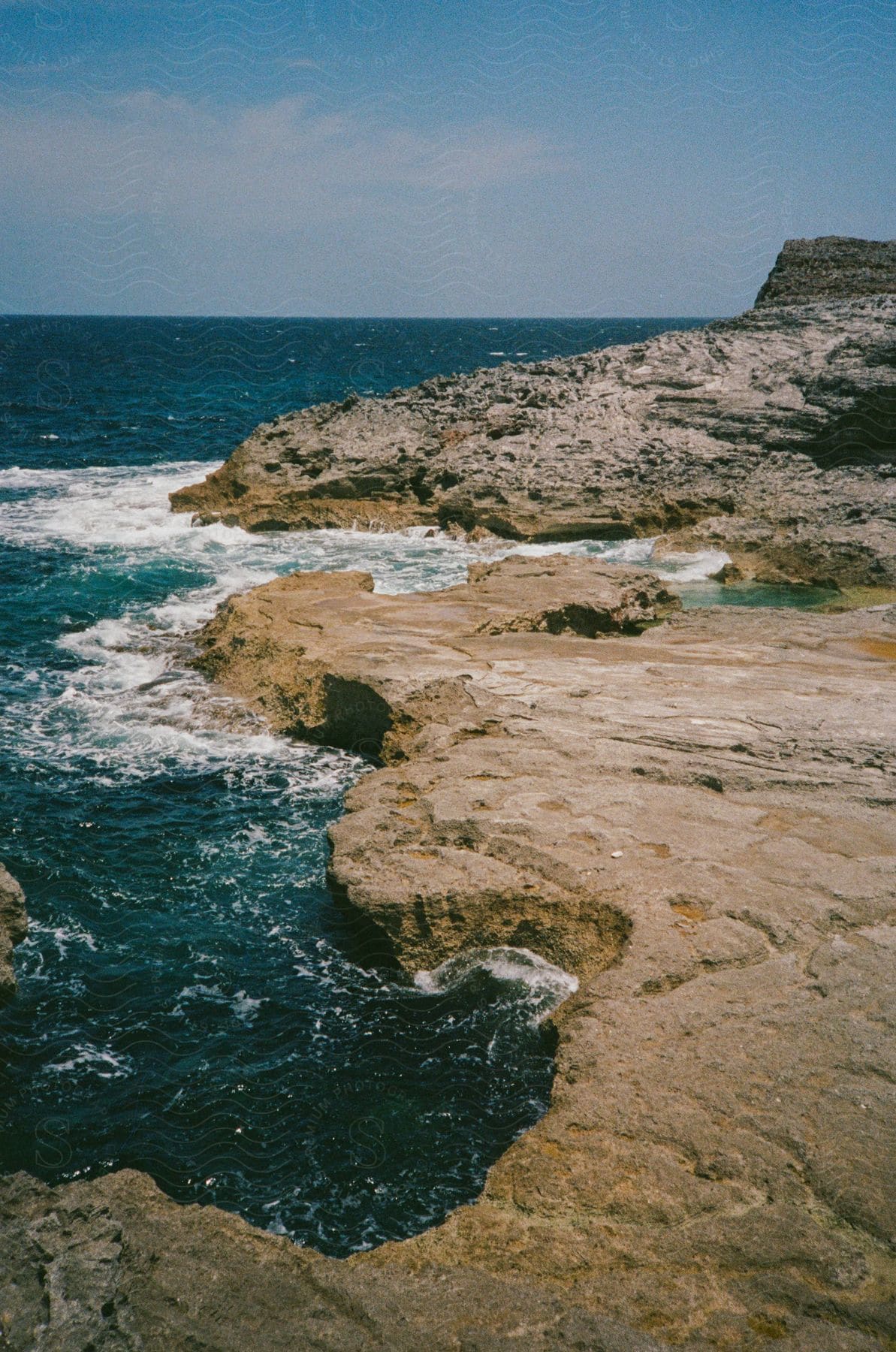 A rocky coastline with waves crashing against the shore