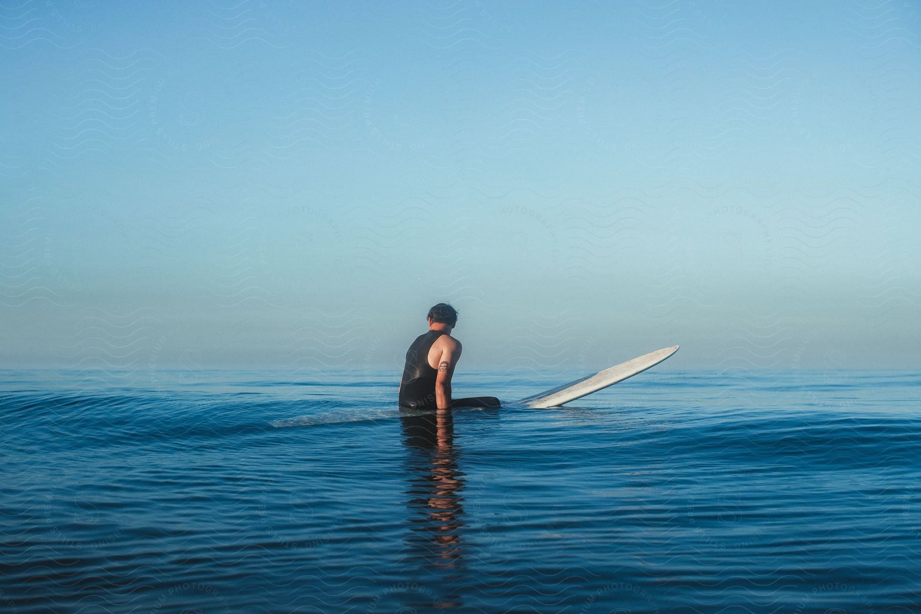 A man sitting on a surfboard in the ocean