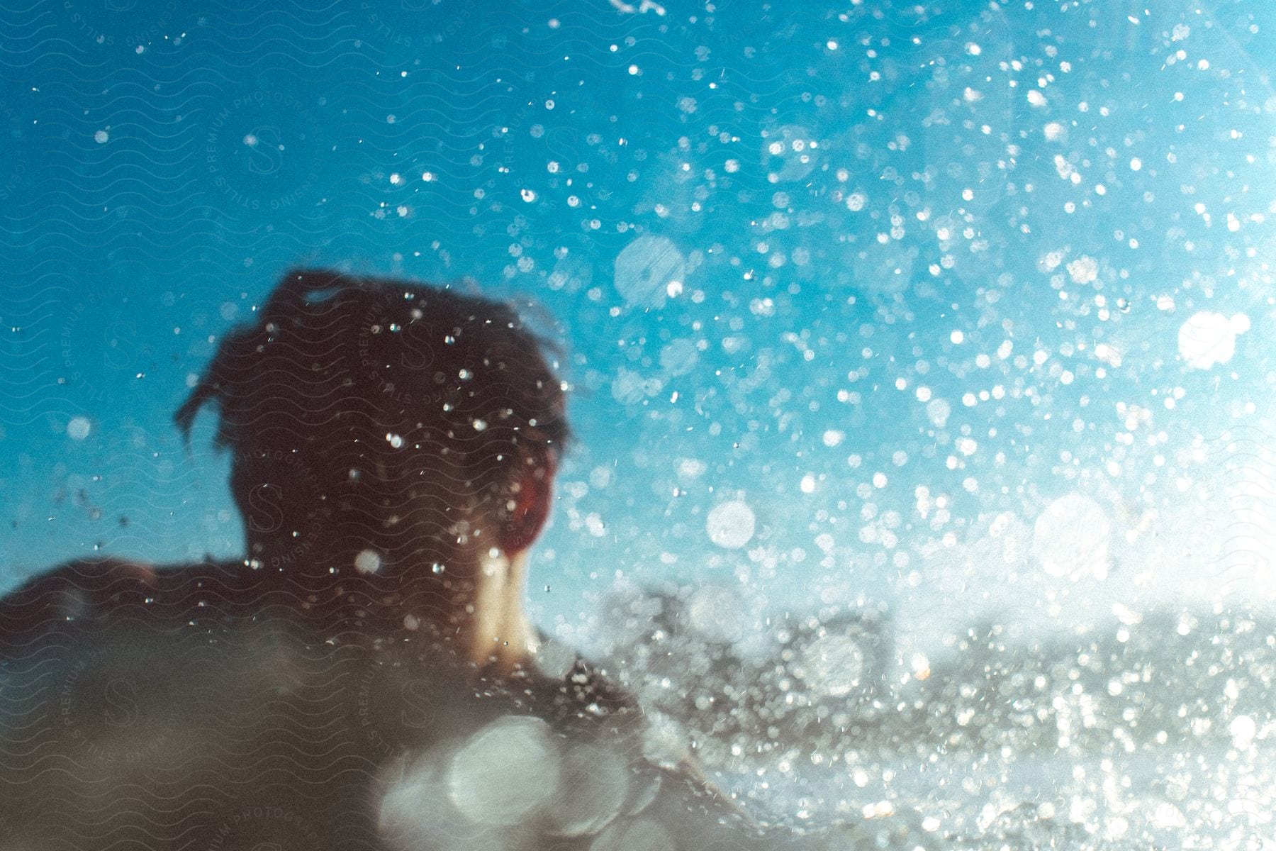 A man swimming outdoors with water splashing around