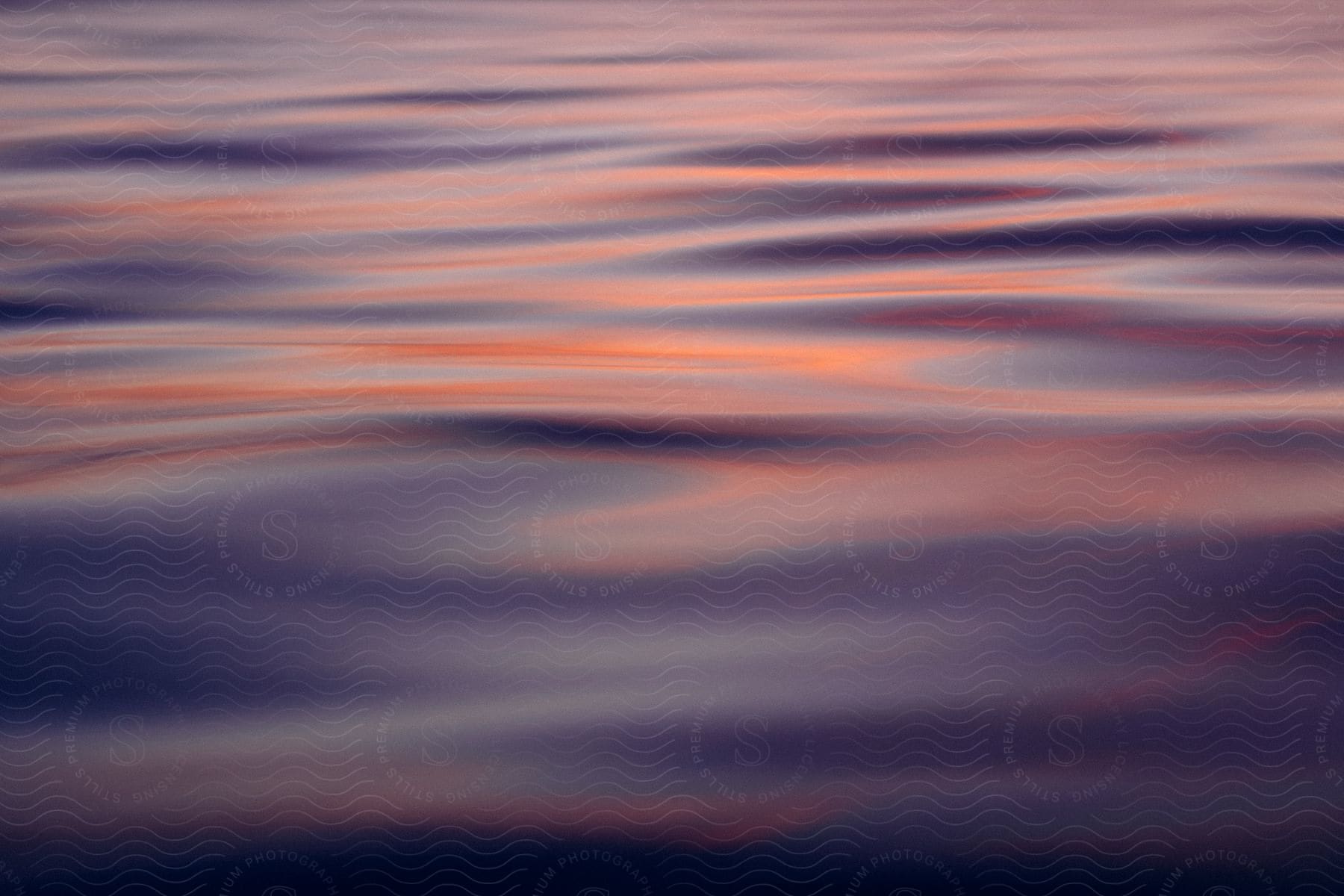 Ripples in water with a multicolored reflection at sunset