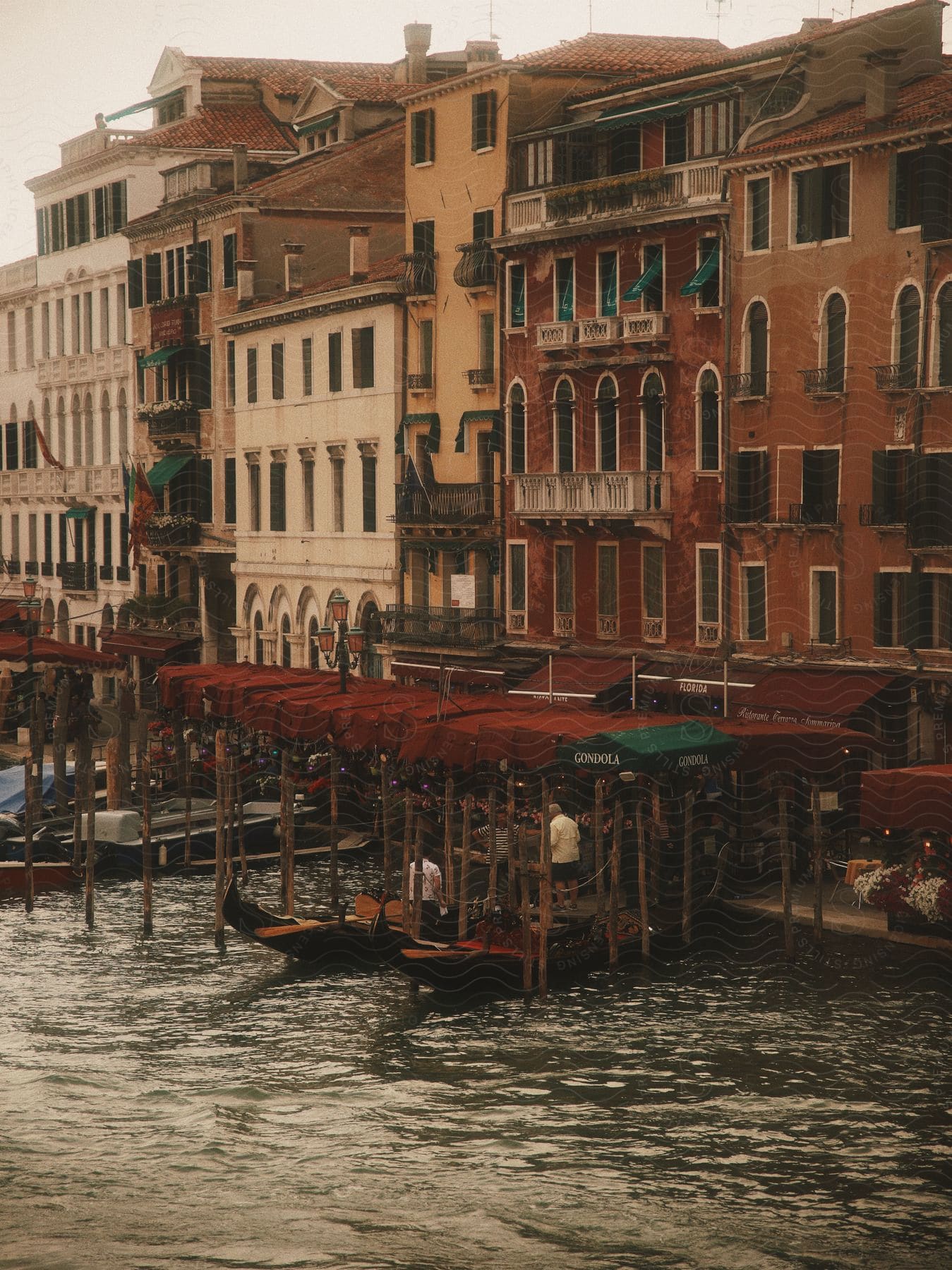 People are near a body of water as they begin to get on a small boat.