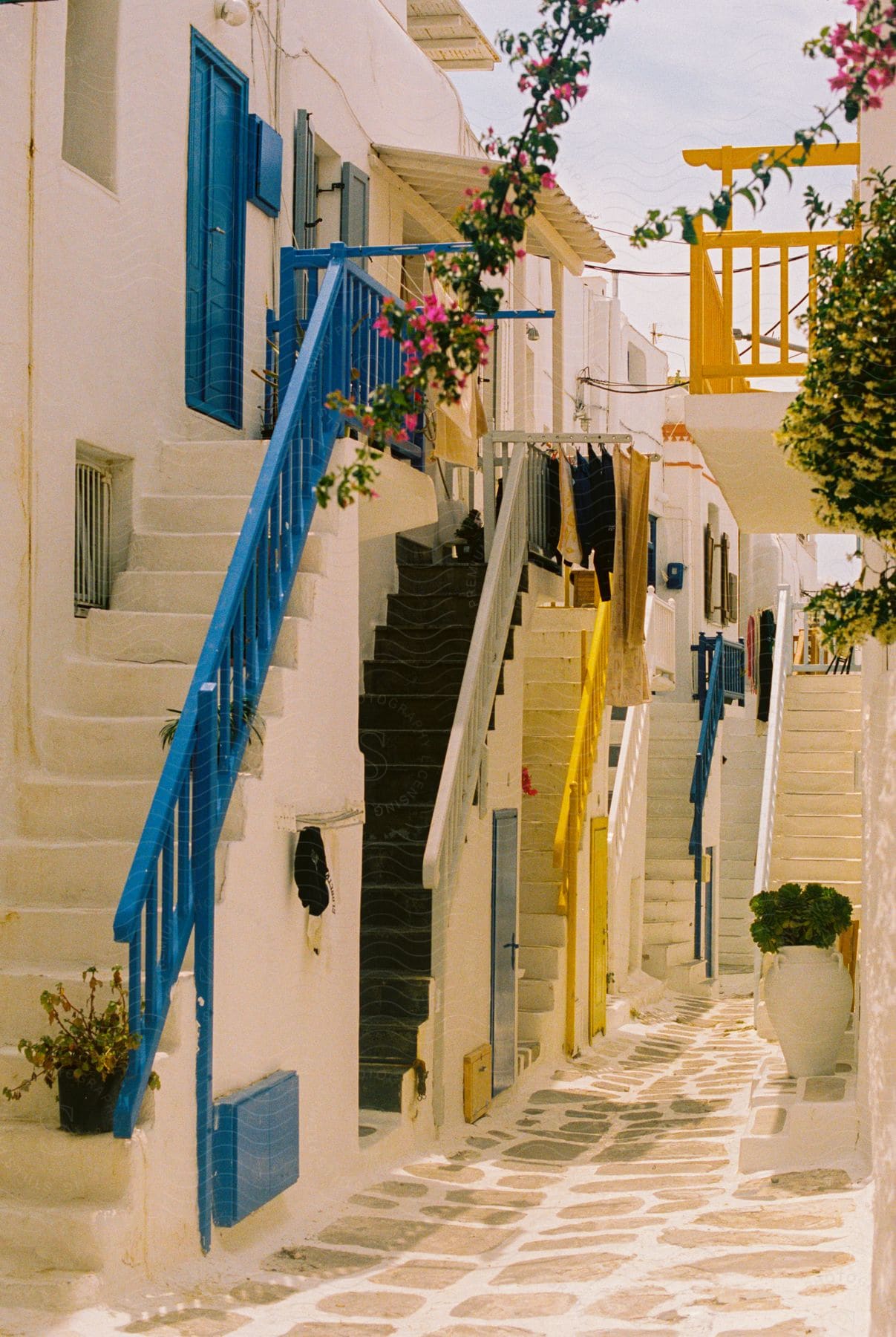 A small town alley and white houses with tall stairs on a sunny day.