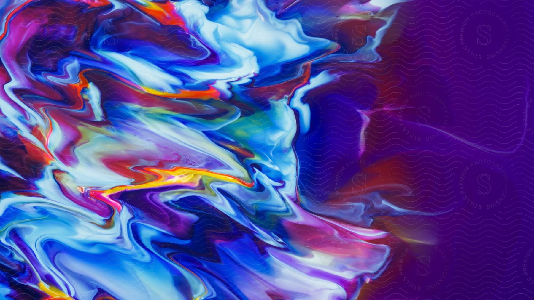 A splatter of yellow mixes with blues and red splashing across a purple background