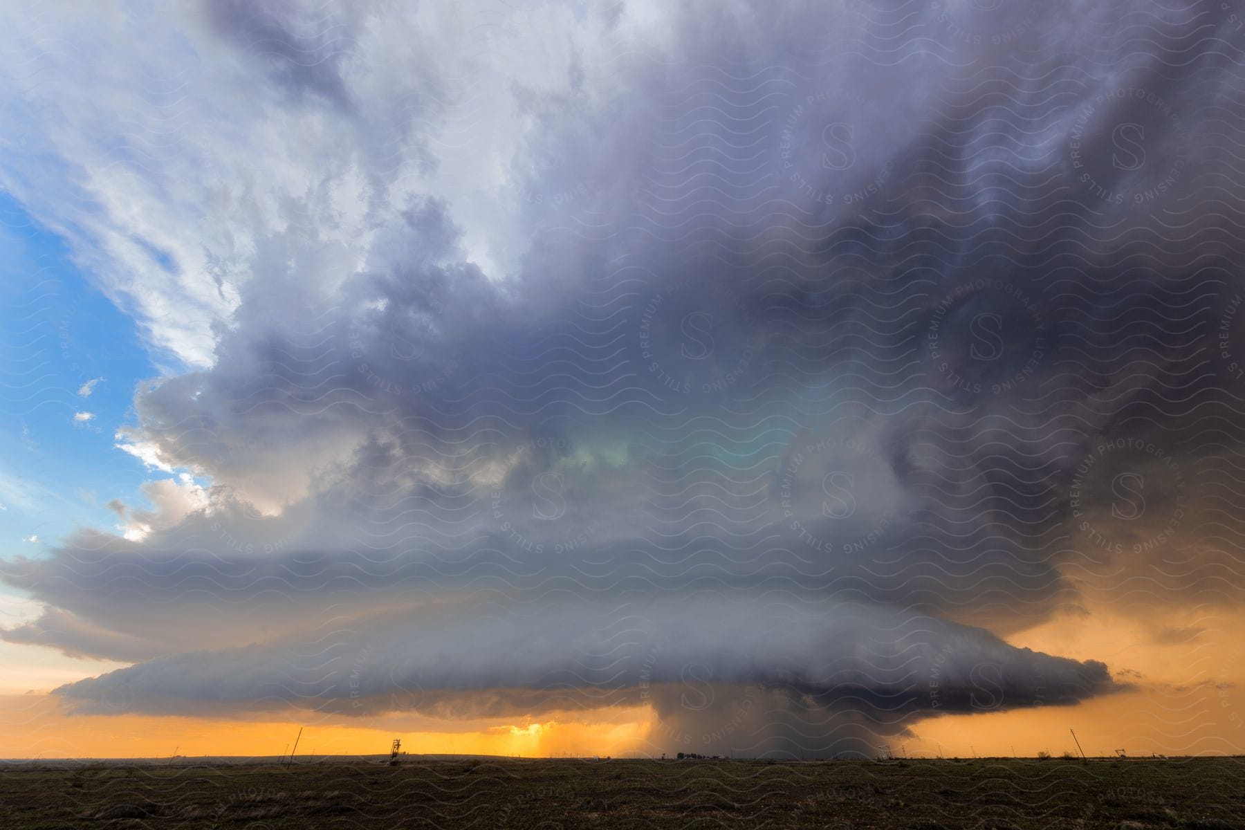 A large rain storm over a large field in the distance